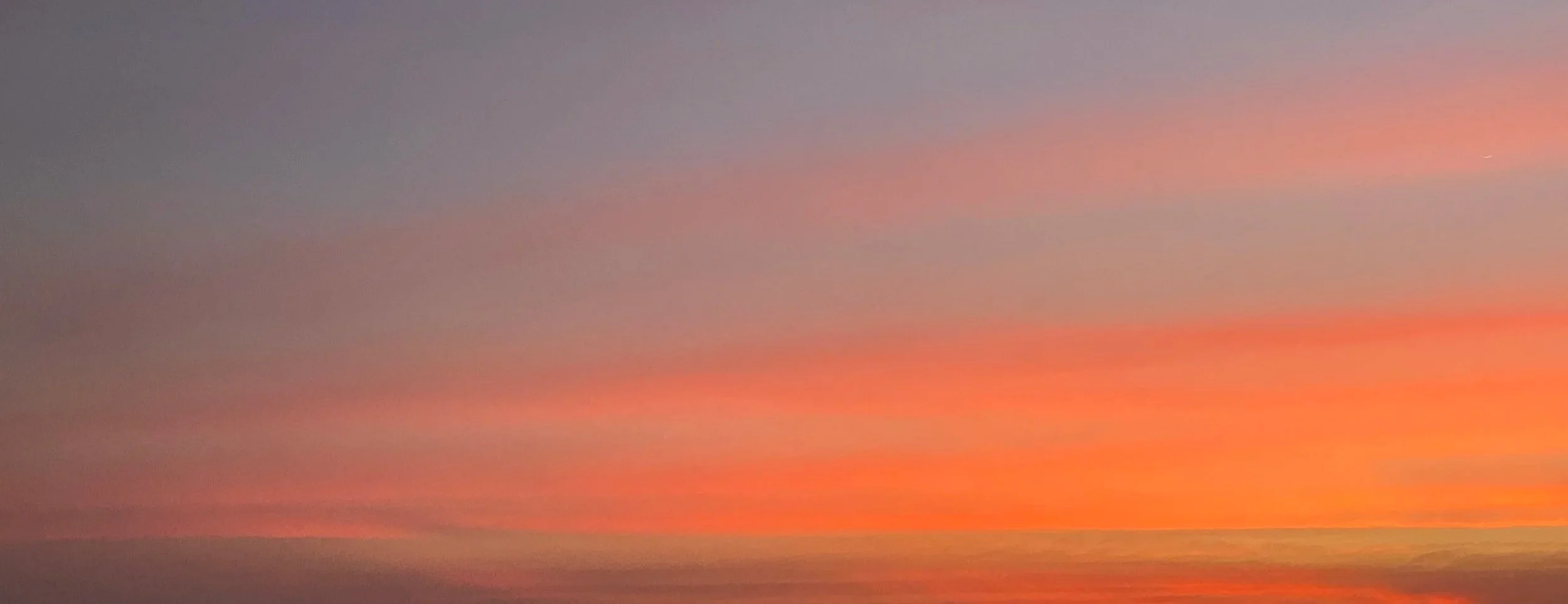 A colorful sunset over the water with a gradient of pink, orange, purple, and blue hues in the sky.