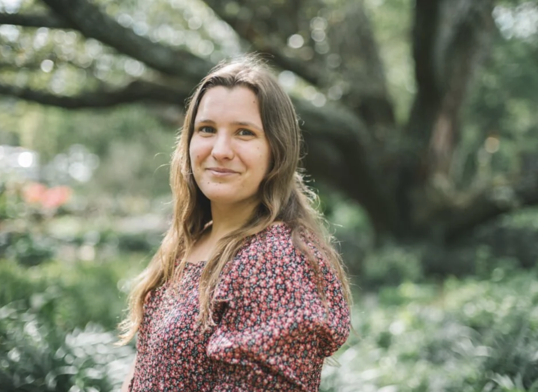 young women with brown hair in front of tree