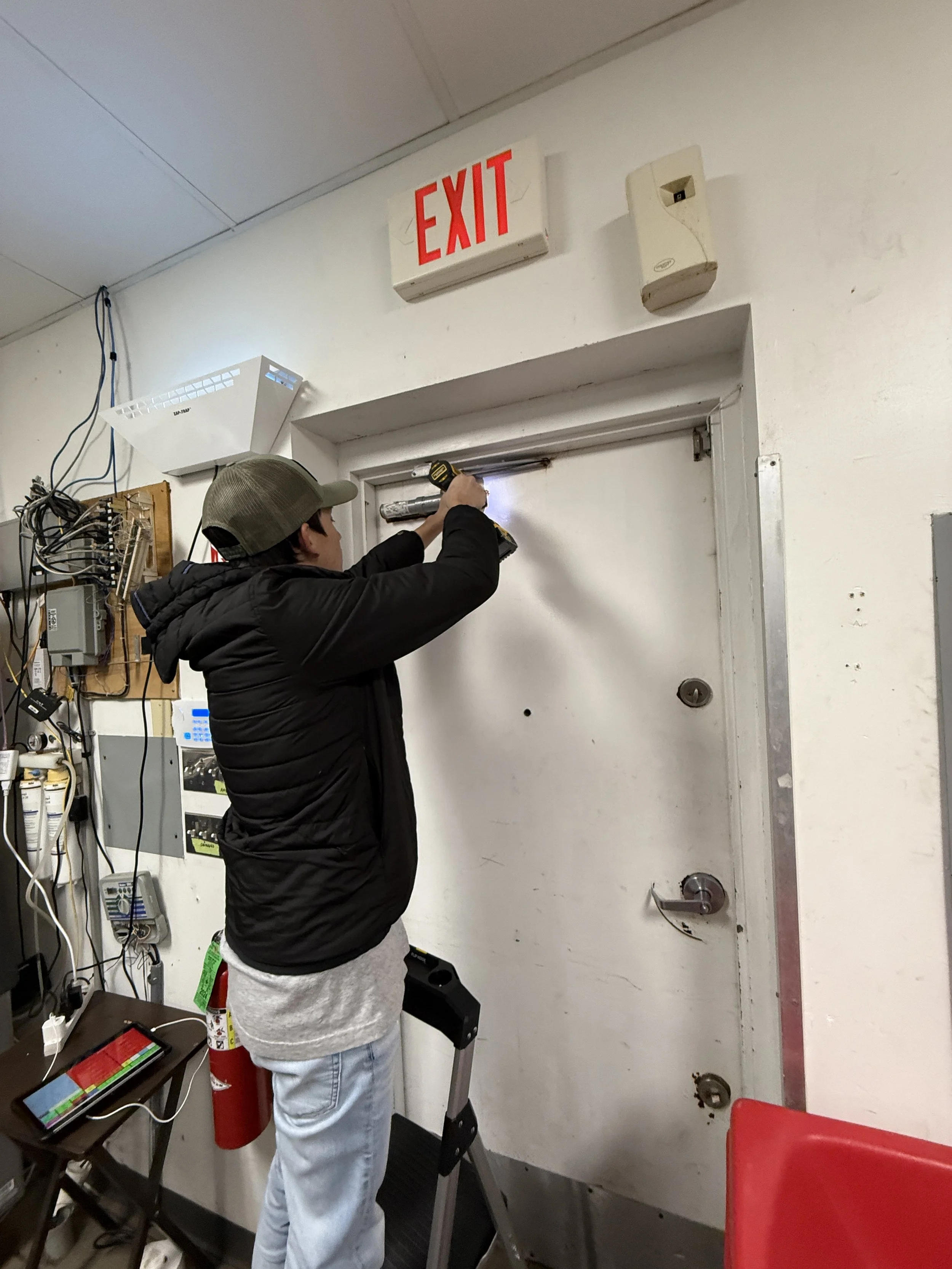 Team member replacing door closer