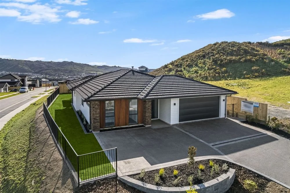 3 Aotea - Full Landscape, Exposed Aggregate Driveway with paved bordered edging and grids, Paved Entranceway, Block Retaining, Aluminium Fencing, Lawn, Planting.jpeg