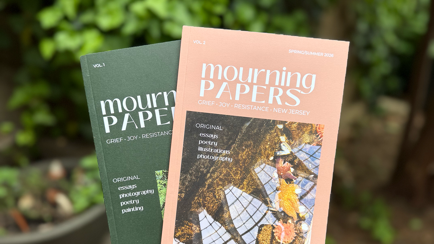 One green and one salmon colored magazine, both titled 'Mourning Papers' with a blurry green background.