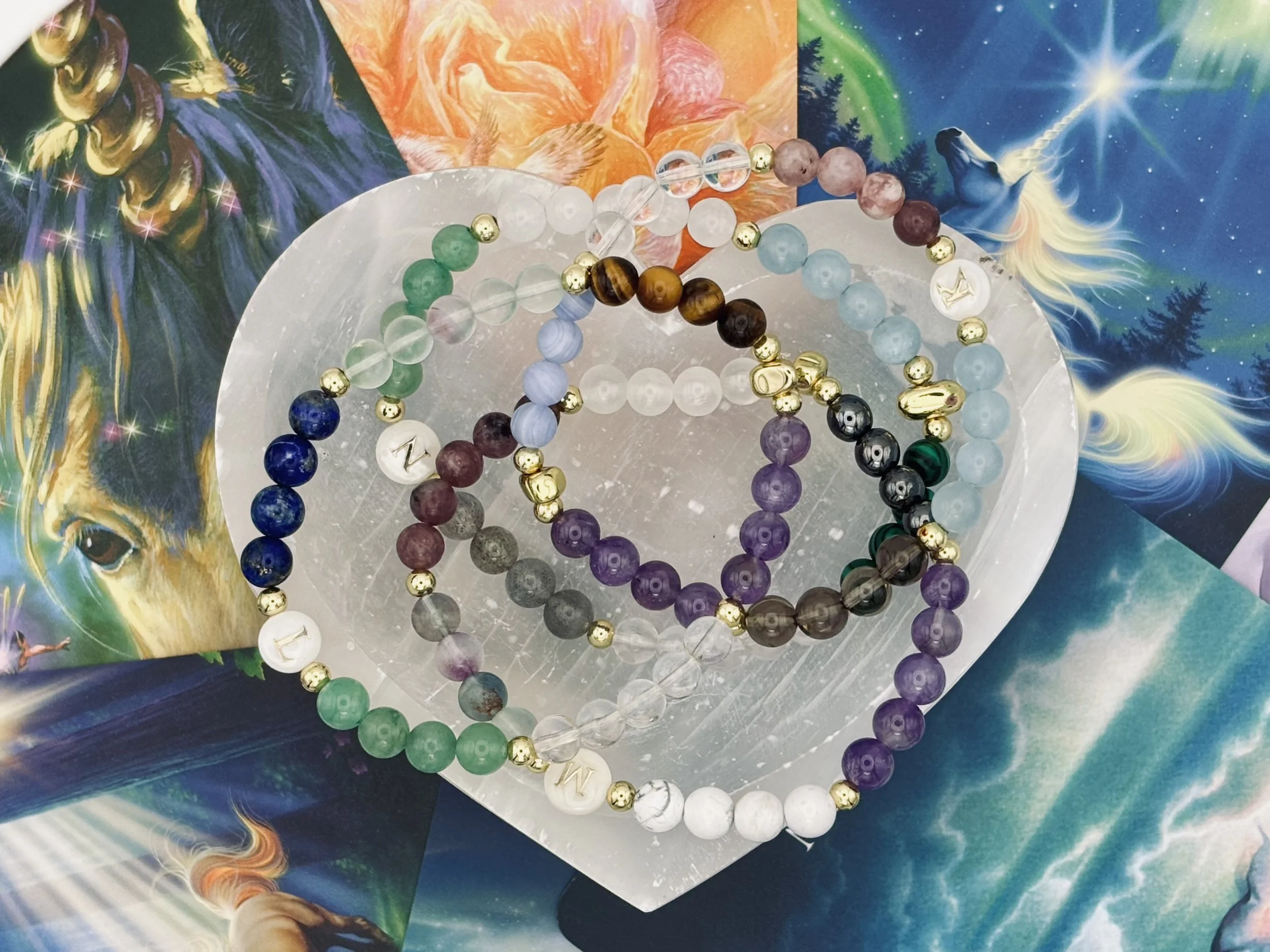 Colorful beaded bracelets arranged on a surface with celestial-themed posters in the background.