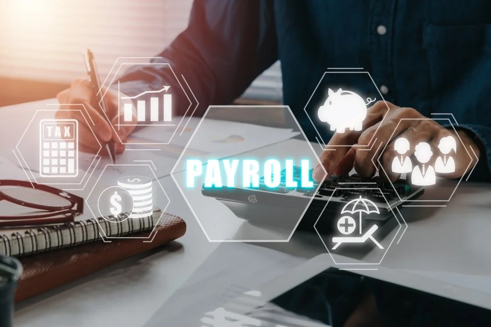 Person working at desk with financial and HR icons overlaid, including payroll, tax, dollar sign, group of people, piggy bank, and health insurance.