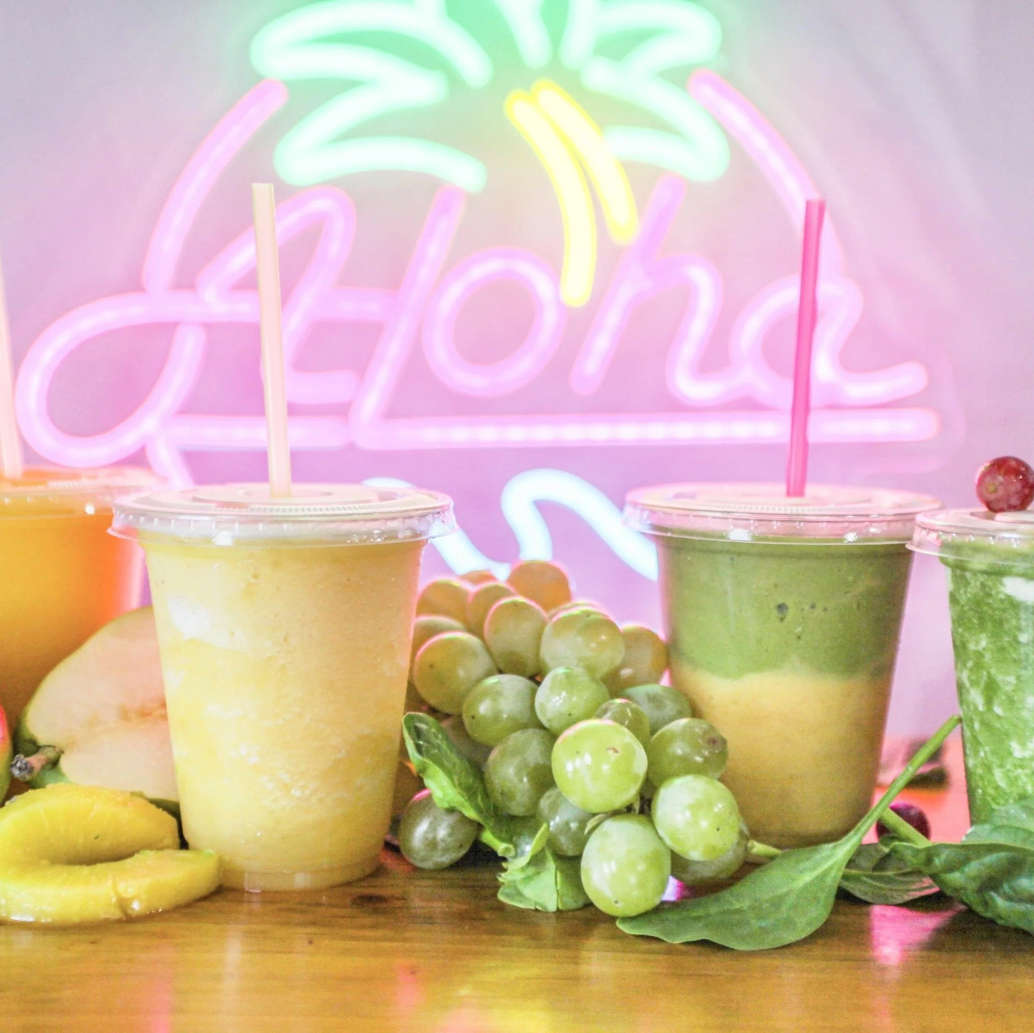 Two smoothies from Aloha Smoothies on a table with grapes