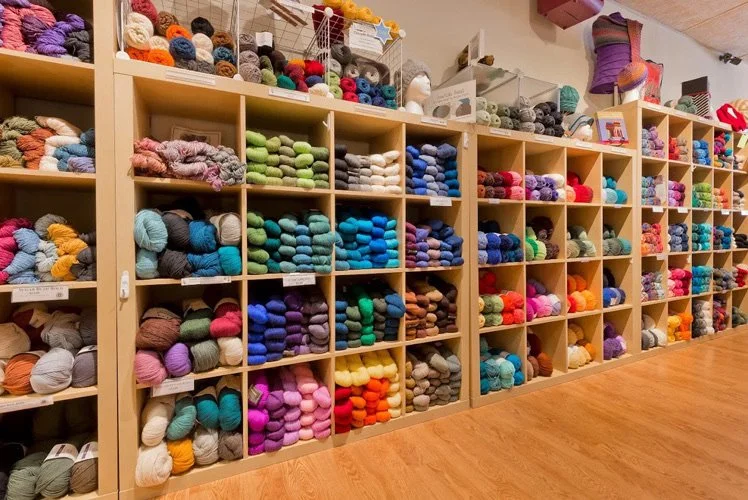 Shelves filled with colorful balls of yarn in a craft store.