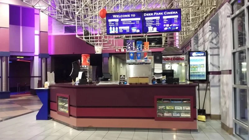 Empty concession stand counter at Deer Park Cinema with Pepsi drinks and a menu board overhead.