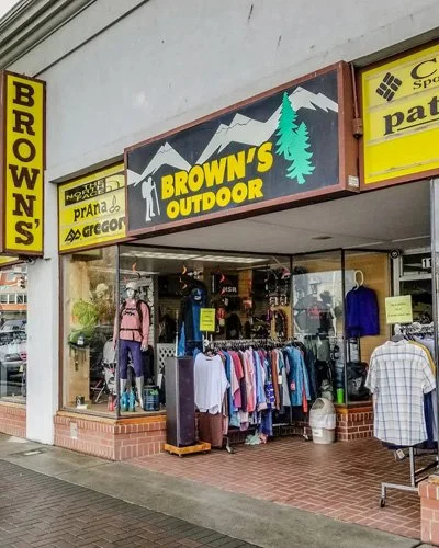 Storefront for Brown's Outdoor, showcasing outdoor clothing and gear, with a prominent signage featuring mountains and trees.