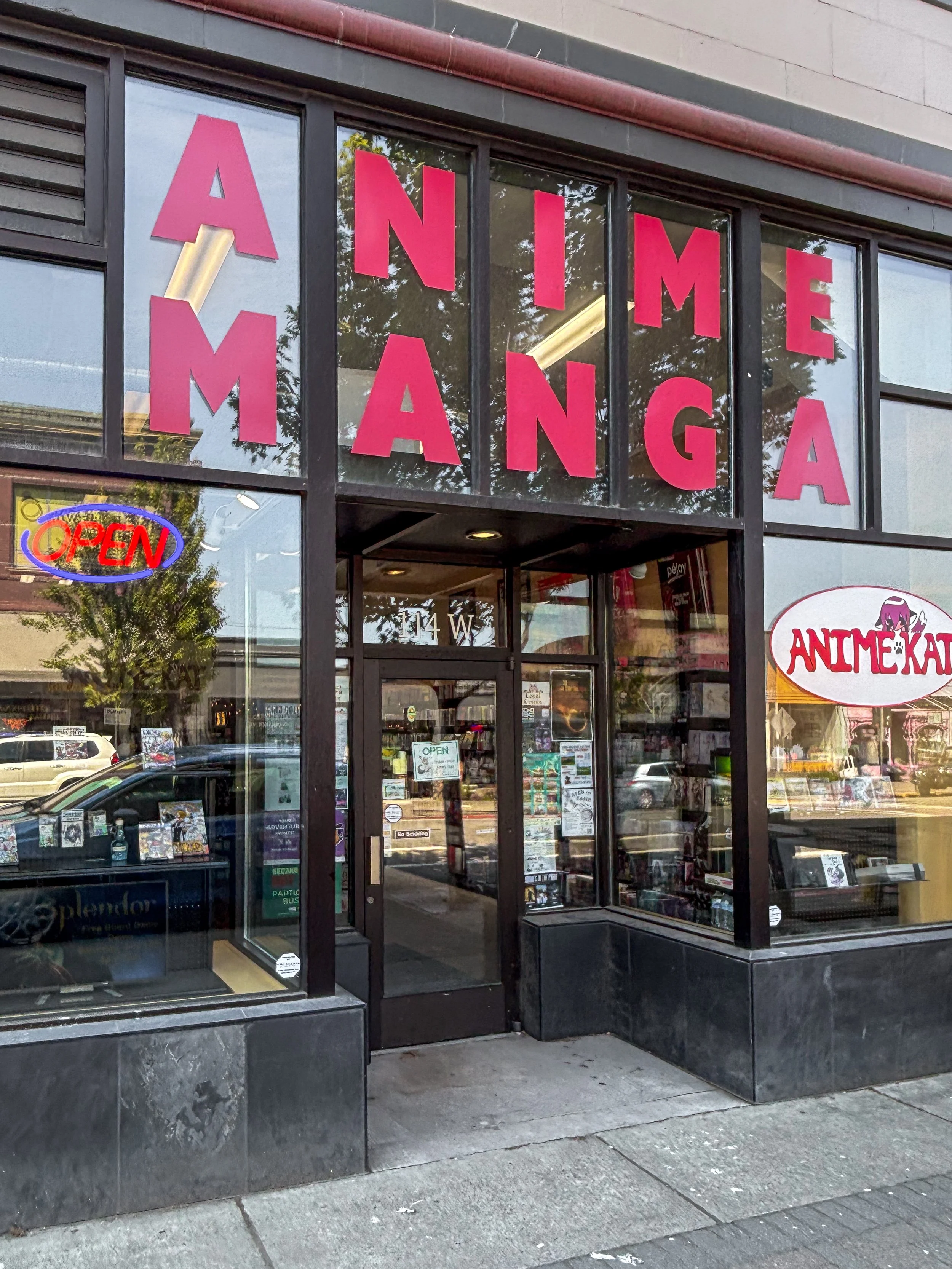 Storefront with large window displays and signage for 'Table Top Games' and 'Anime Manga' in red lettering, with promotional posters visible in the window.