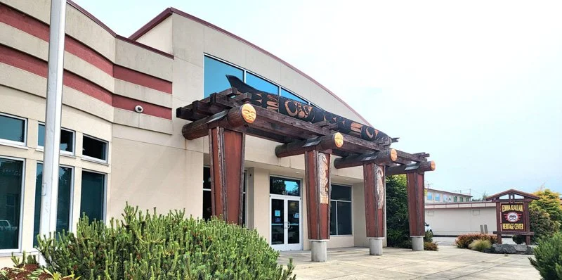 Exterior of a building with a wooden pergola and a sign indicating a sushi restaurant.