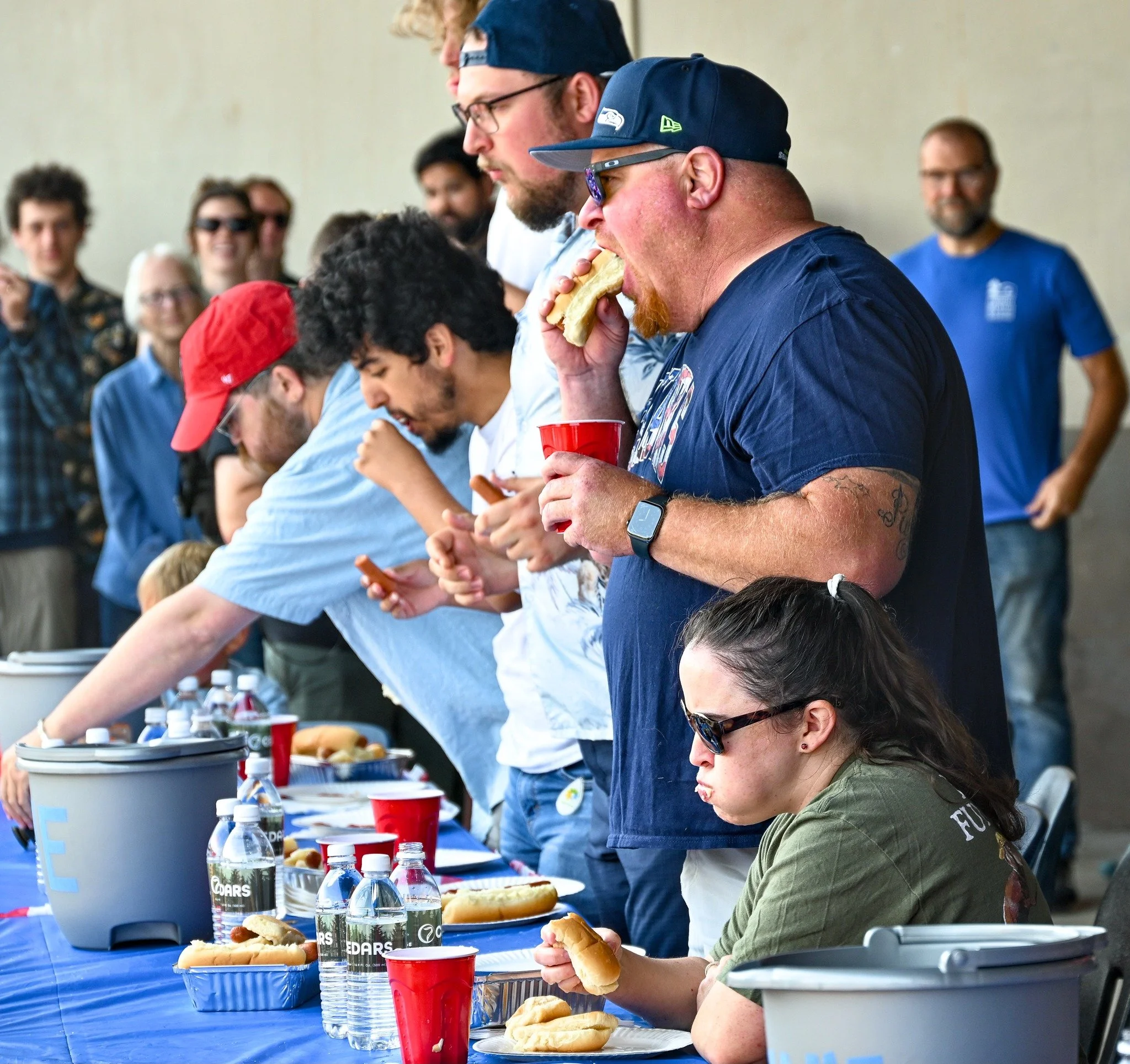 A candid photo of people eating hot dogs during Uncle Sam's hot dog eating contest