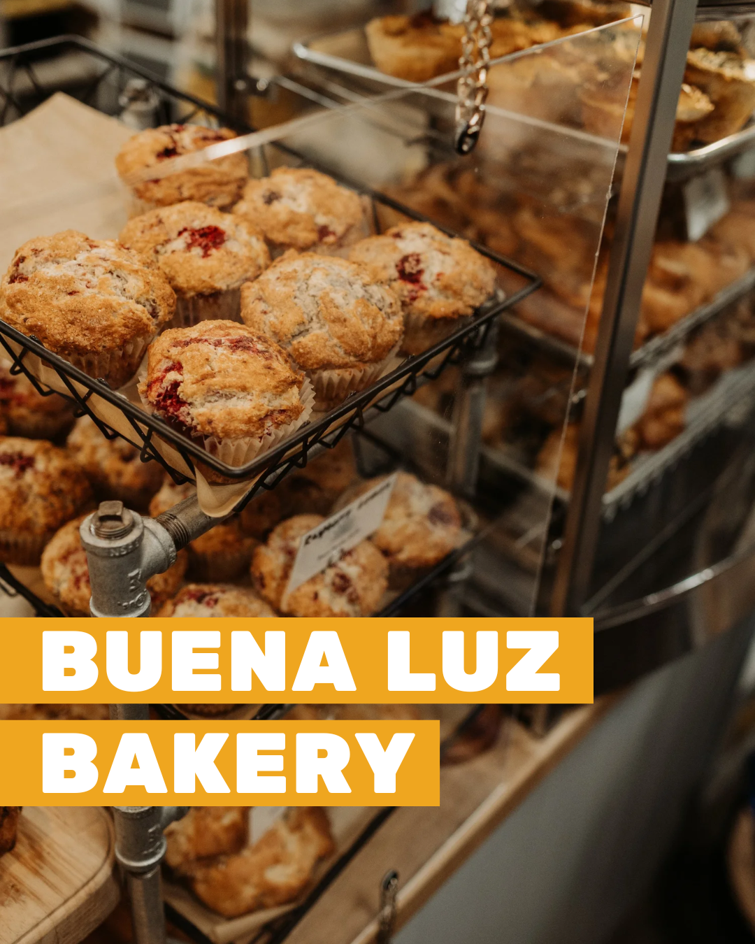 Homemade muffins stacked on display at Buena Luz Bakery.