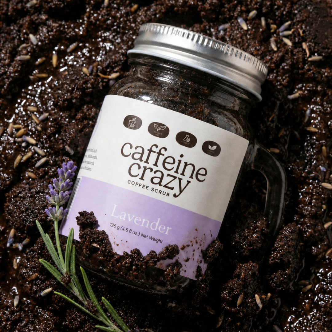 Lavender Coffee Scrub laying in caffeine crazy coffee scrub with a sprig and lavender flowers surrounding the product.