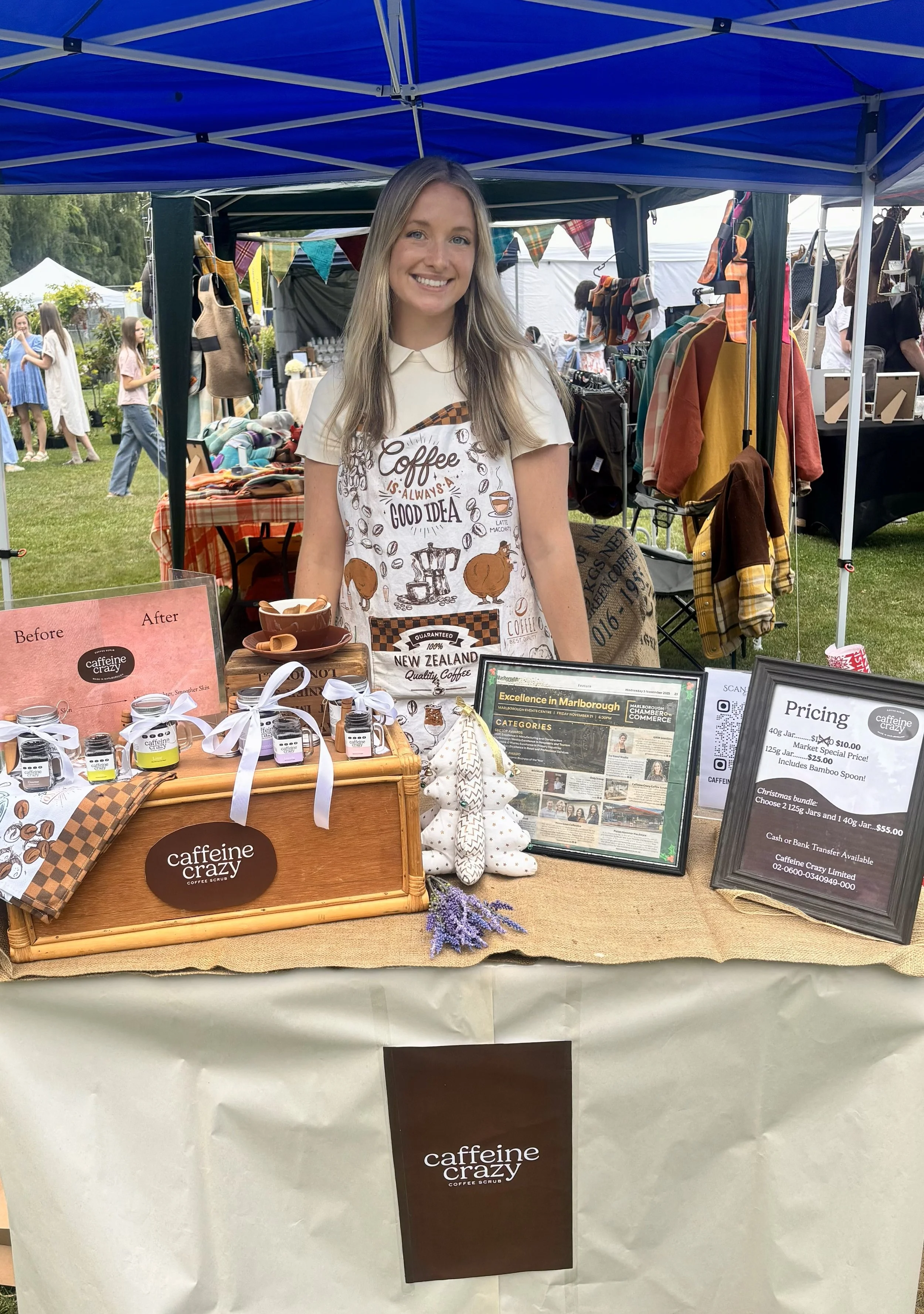 Megan Berlin, the Founder, standing at the market stall at the Mistletoe Market in Blenheim, New Zealand at Pollard Park on December 6, 2025 selling Coffee Scrubs for Caffeine Crazy Coffee Scrub.