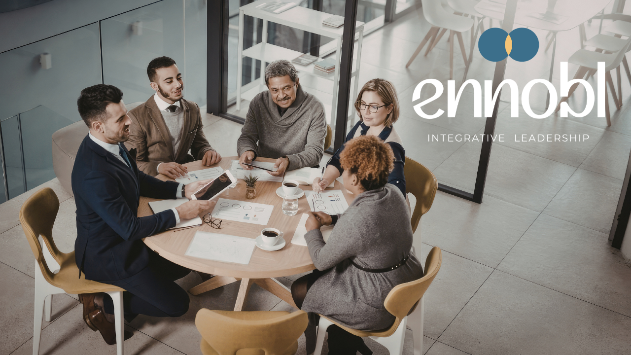 Business people sitting at a round conference table having a meeting.