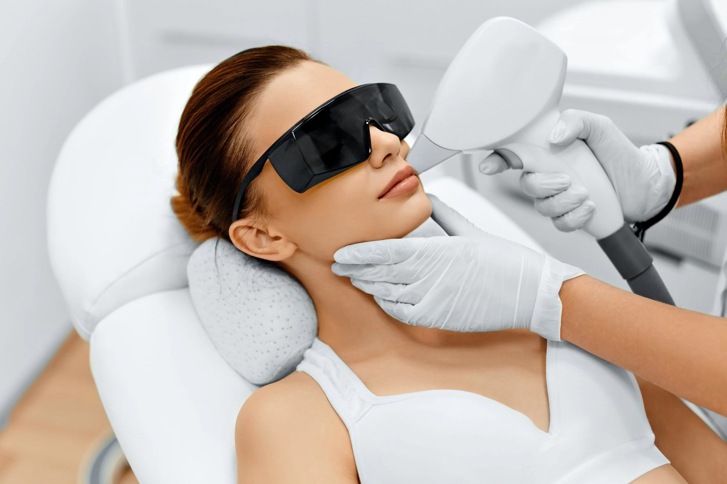 Woman receiving laser skin treatment while wearing protective goggles