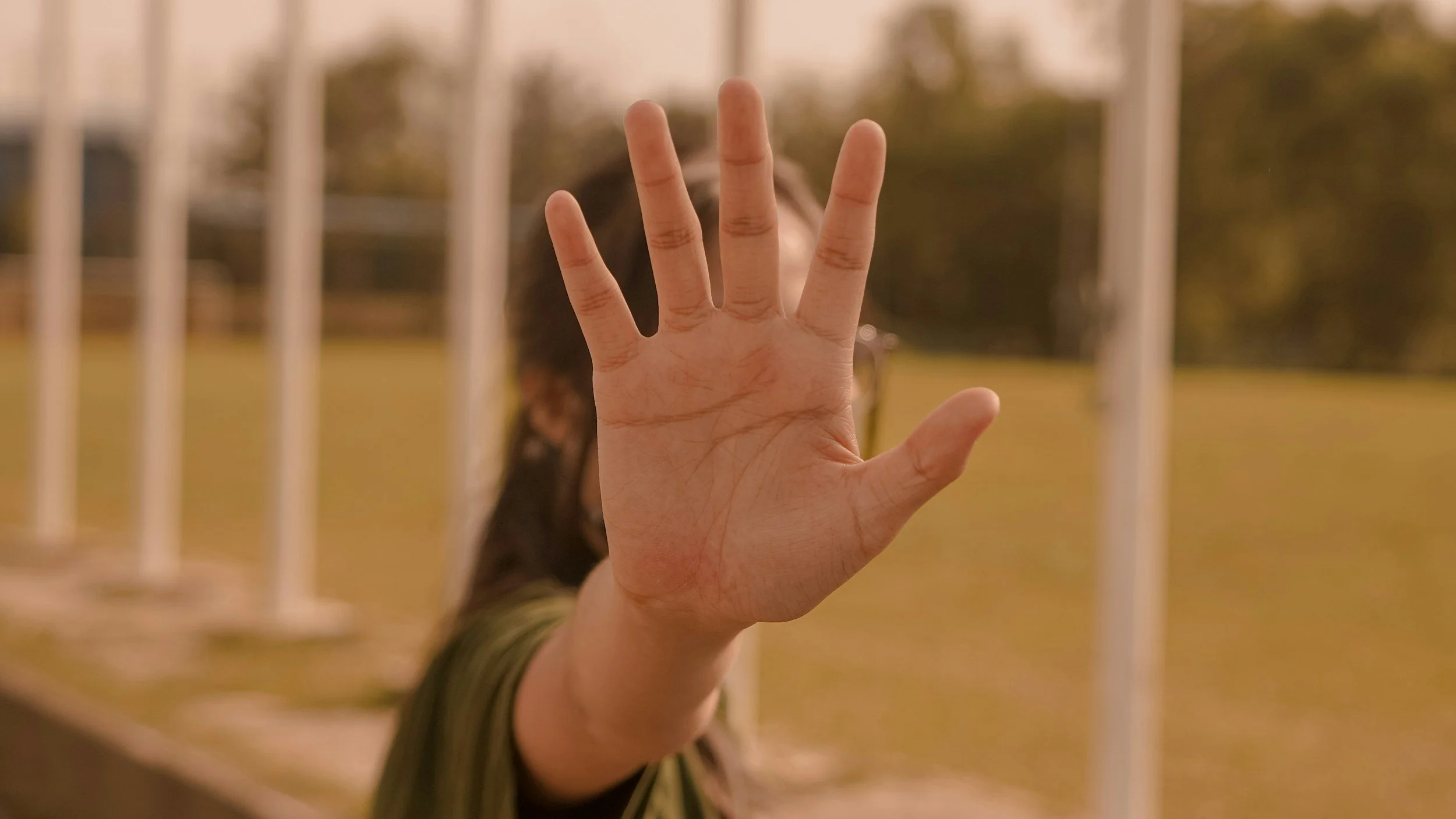 Image of a woman holding up her hand to indicate "stop".