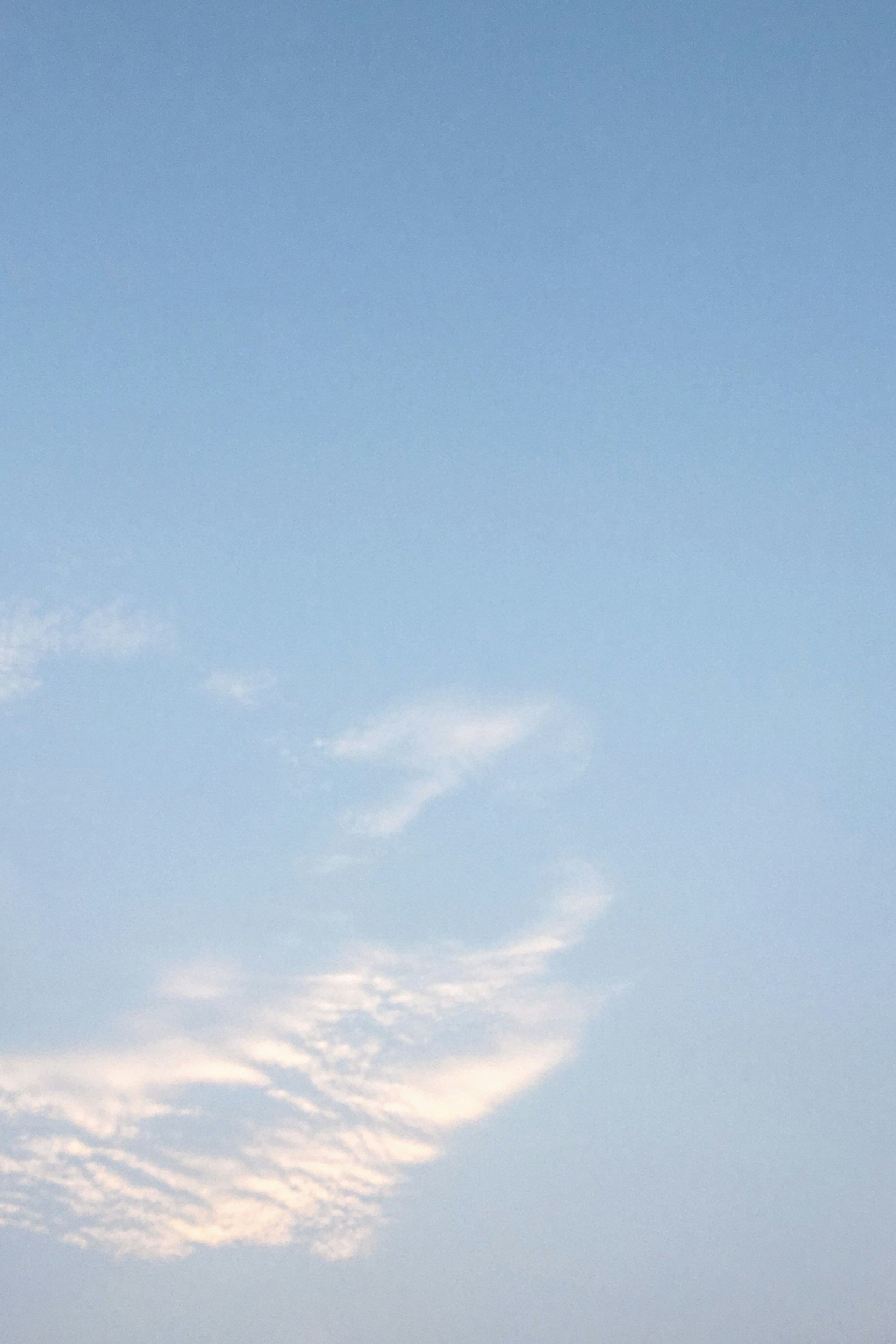 Image of a light blue sky with puffy clouds.
