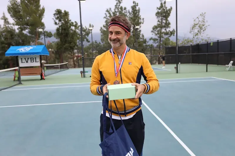 Greg getting medal after playing tennis