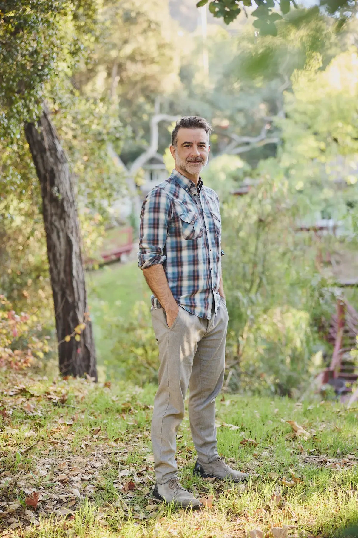 male standing among trees with hands in pocket