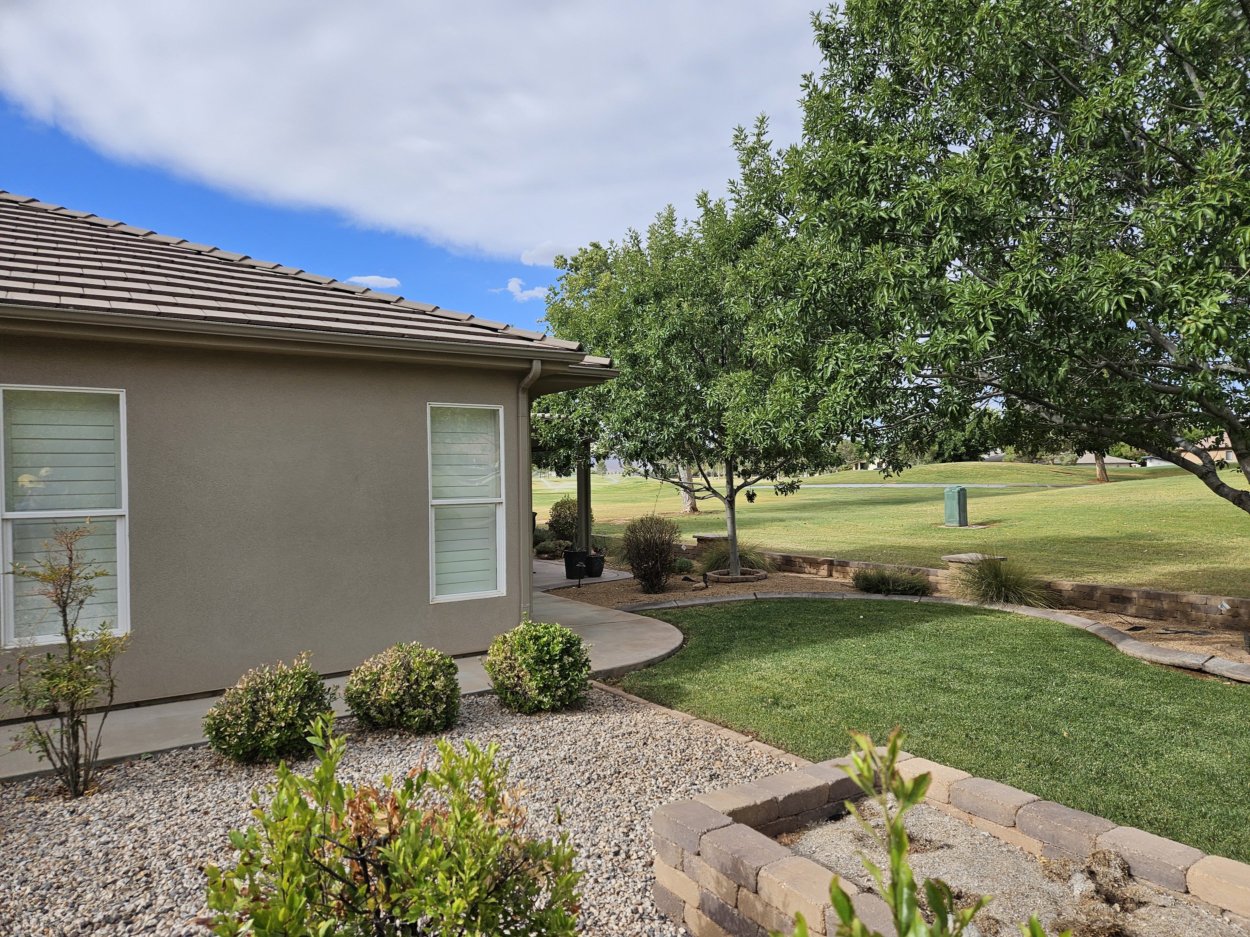 This St. George Utah property displays expertly shaped trees and a manicured yard, demonstrating professional tree pruning and maintenance services. Certified arborists in Southern Utah provide trimming, shaping, and ongoing tree care designed to sup