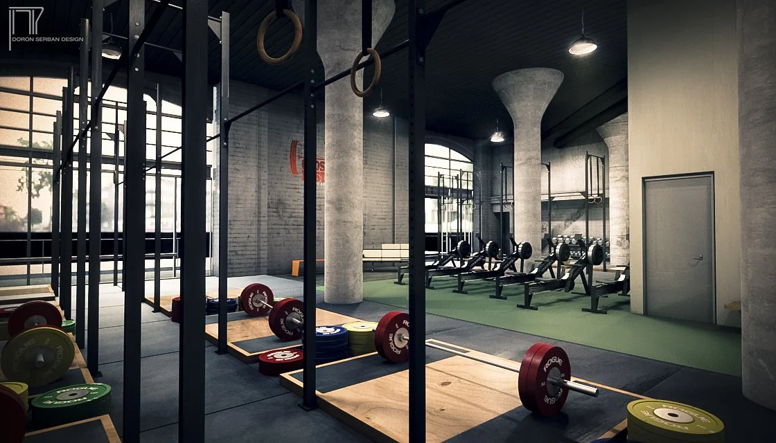 Interior view of a modern gym with weightlifting equipment, including barbells, weight plates, and gymnastic rings hanging from the ceiling.