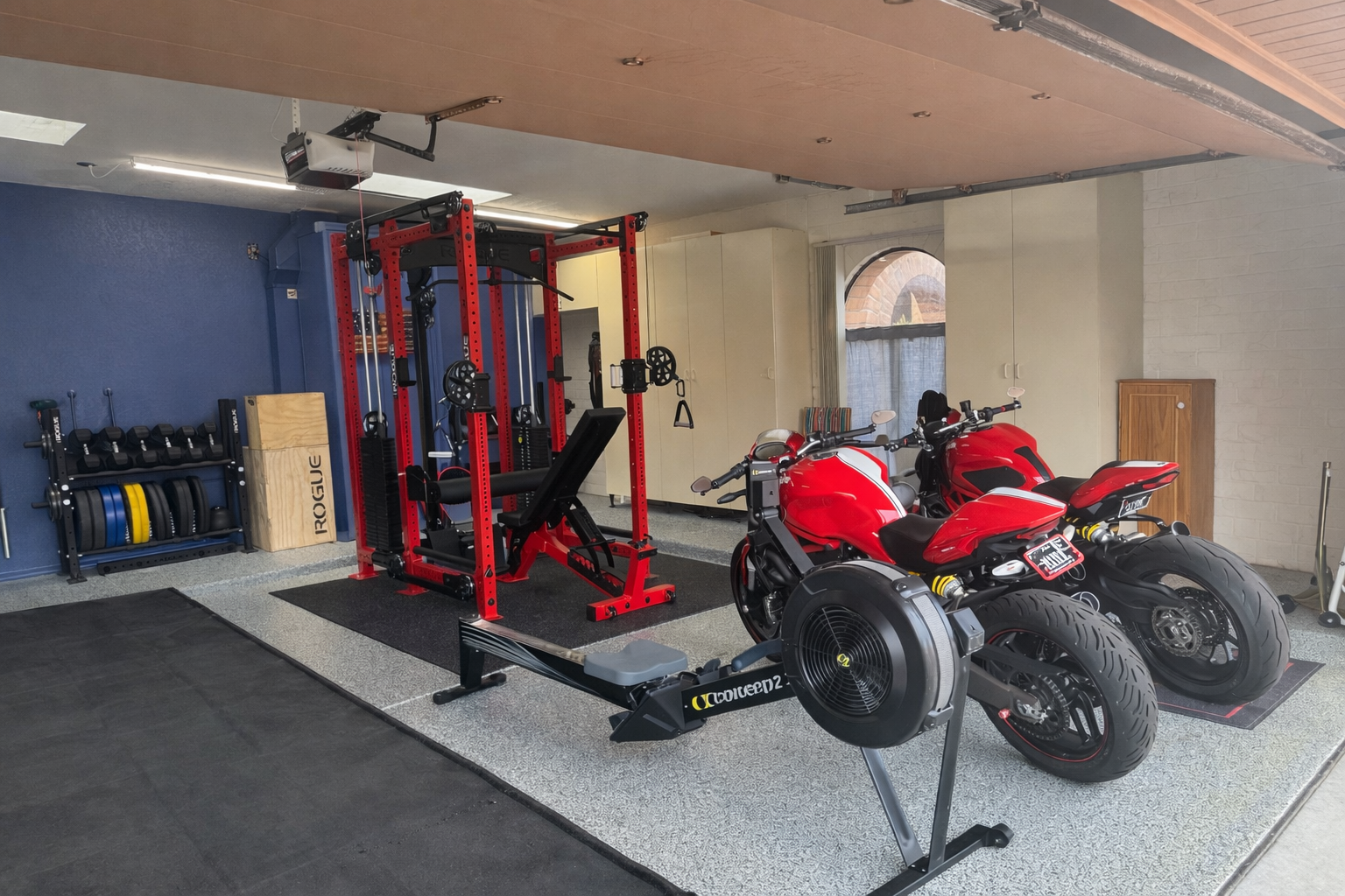 Private boutique home gym in Catalina Foothills, Tucson, featuring a red and black Rogue power rack, bench, and free weights.