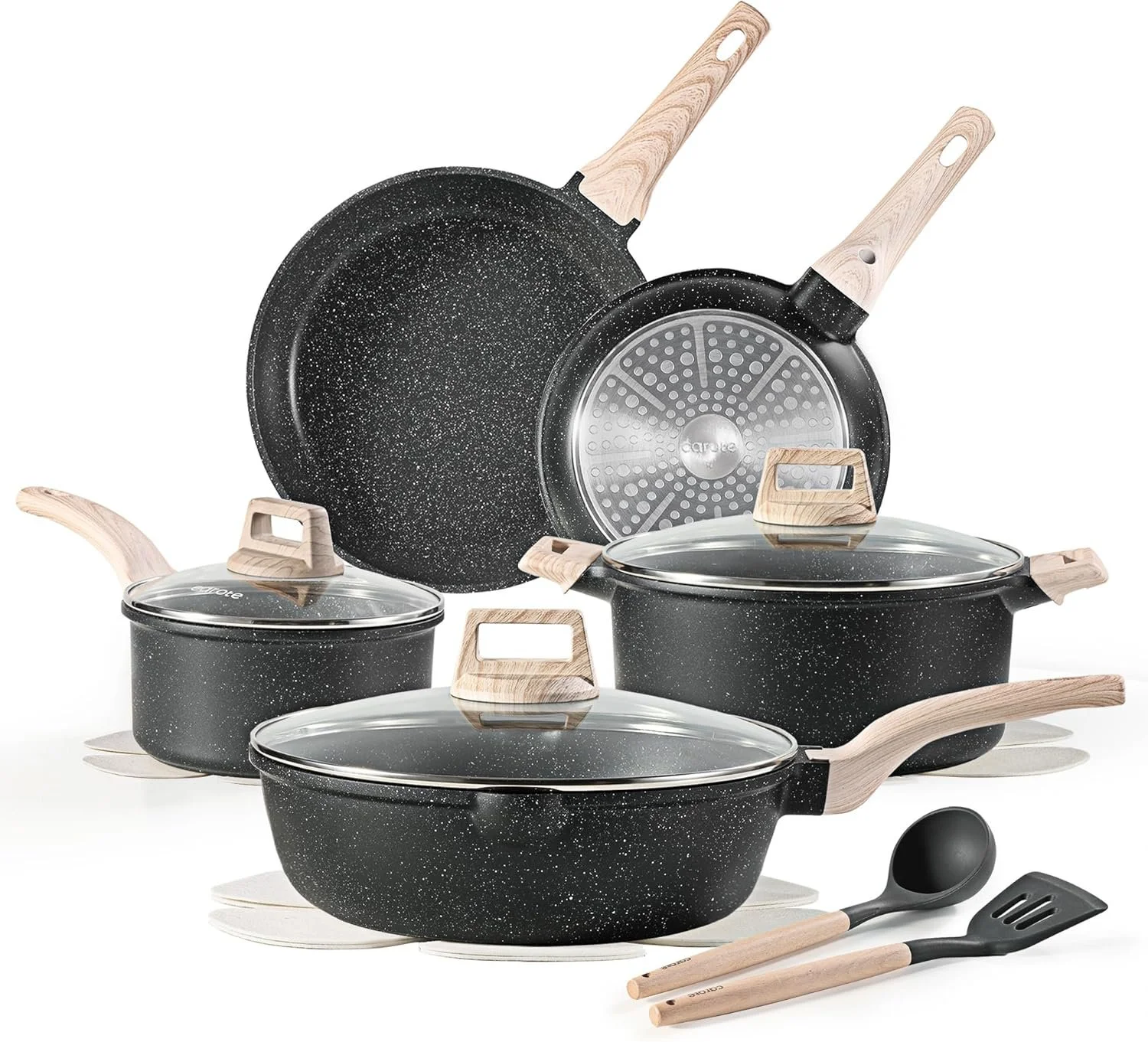 Set of black non-stick cookware with speckled pattern, wooden handles, glass lids, and cooking utensils.