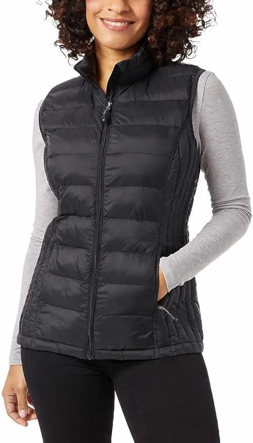 A woman wearing a black quilted sleeveless puffer vest with a high collar, paired with a light gray long-sleeve shirt underneath, against a plain background.
