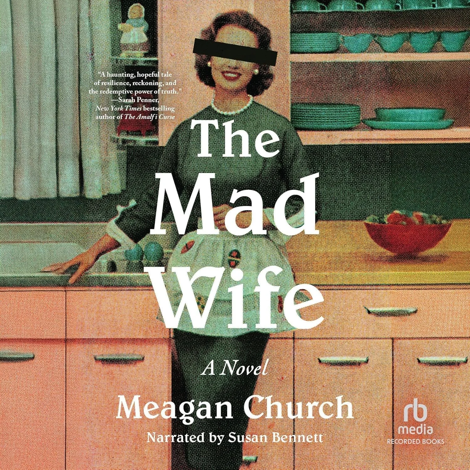Cover art for the audiobook 'The Mad Wife' showing a woman in a vintage kitchen, with a black bar over her eyes, wearing a dark top and a light skirt with a pattern, smiling and standing near a counter with a bowl of strawberries.