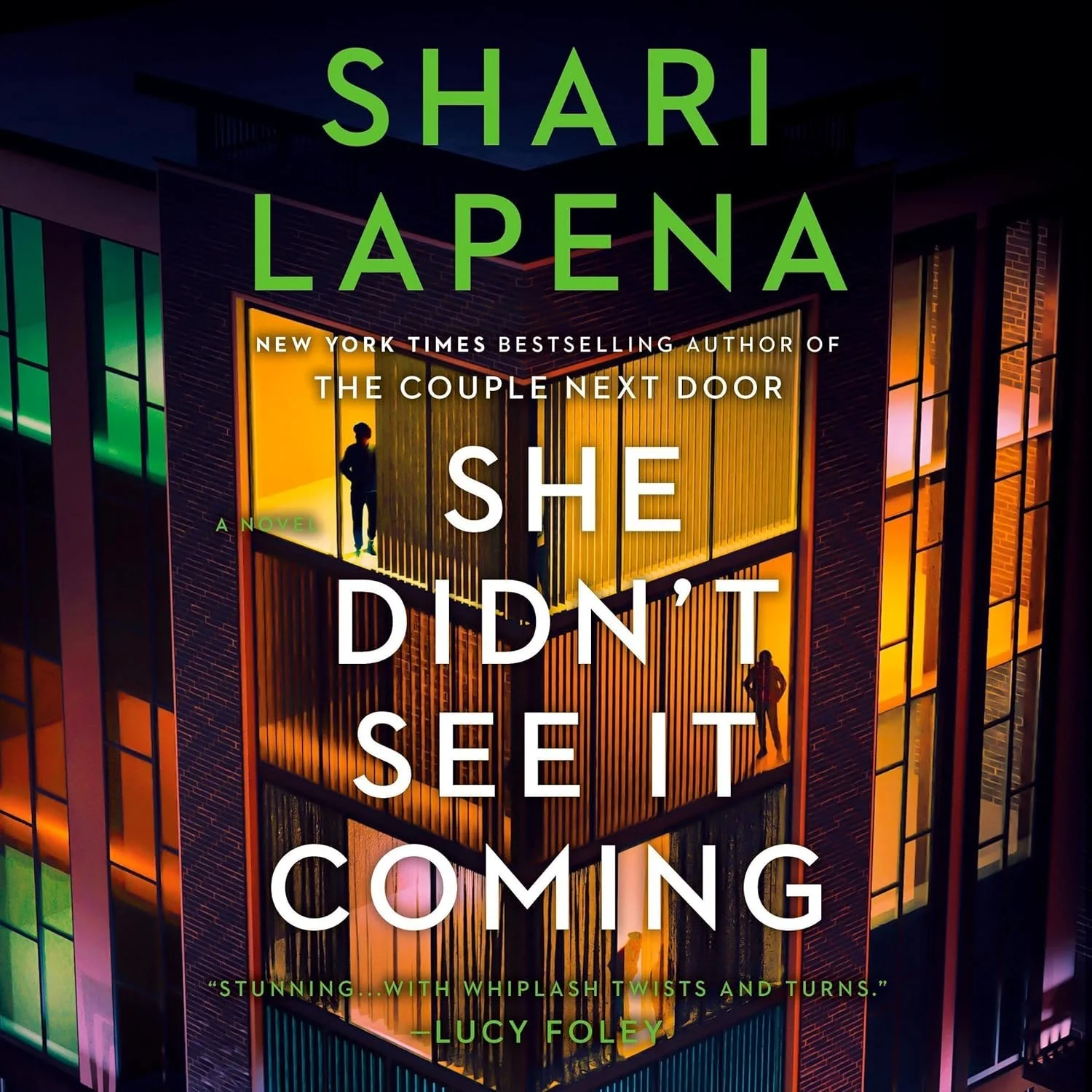 Book cover for 'She Didn't See It Coming' by Shari LaPena, featuring an illustration of a modern building with illuminated windows and silhouettes of people inside.