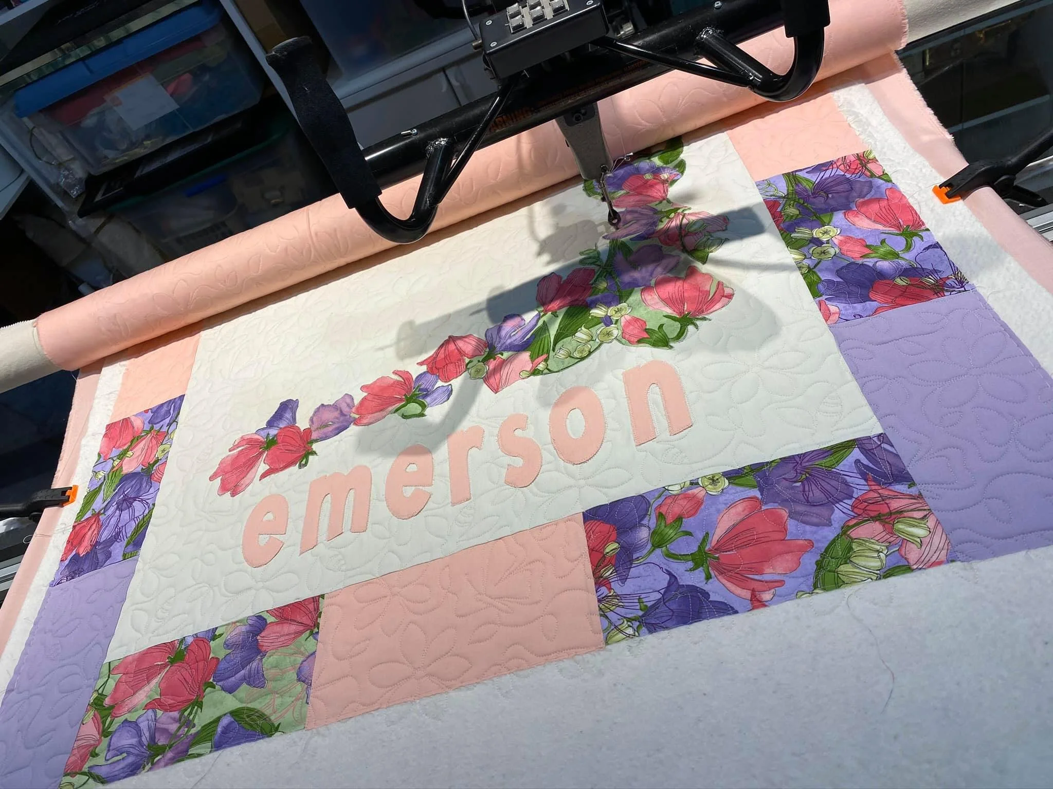 longarm quilting machine stitching a quilt with animals.