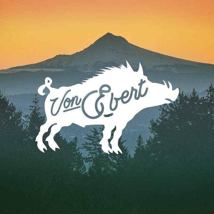 Von Ebert Brewing logo with a silhouette of a wild boar with the words 'Von Ebert' inside it, set against a background of mountains and trees at sunset.