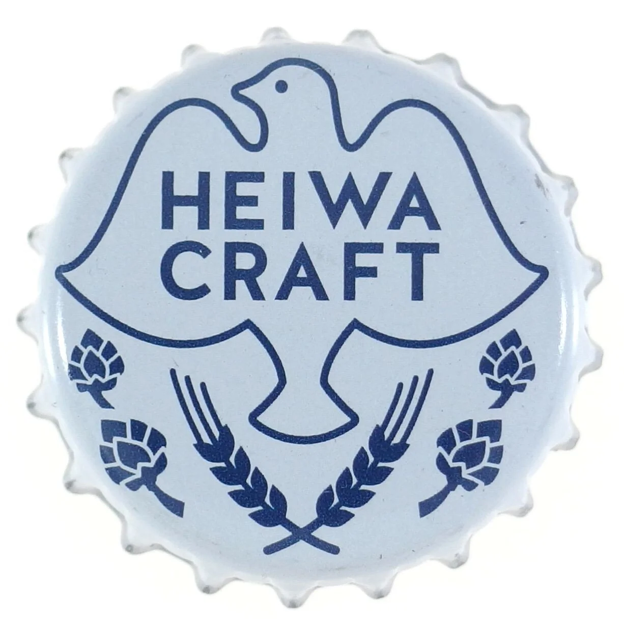 A circular metal bottle cap with a blue design and text that reads 'HEIWA CRAFT.' The design features a stylized leaf or hop outline with two crossed wheat or hop elements below.