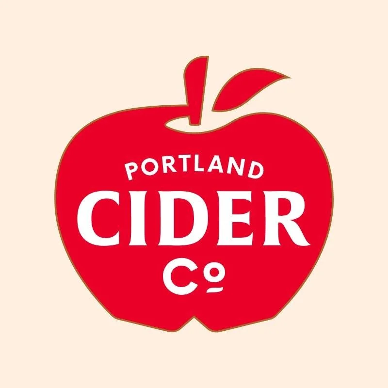 Logo for Portland Cider Co. featuring a red apple with white text.