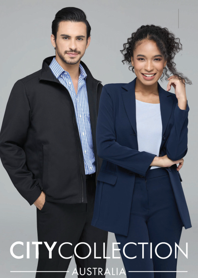 Two professionally dressed individuals, a man and a woman, standing against a plain background. The man is wearing a black jacket over a blue and white checkered shirt, and the woman is wearing a navy blue blazer and pants with a light blue shirt und