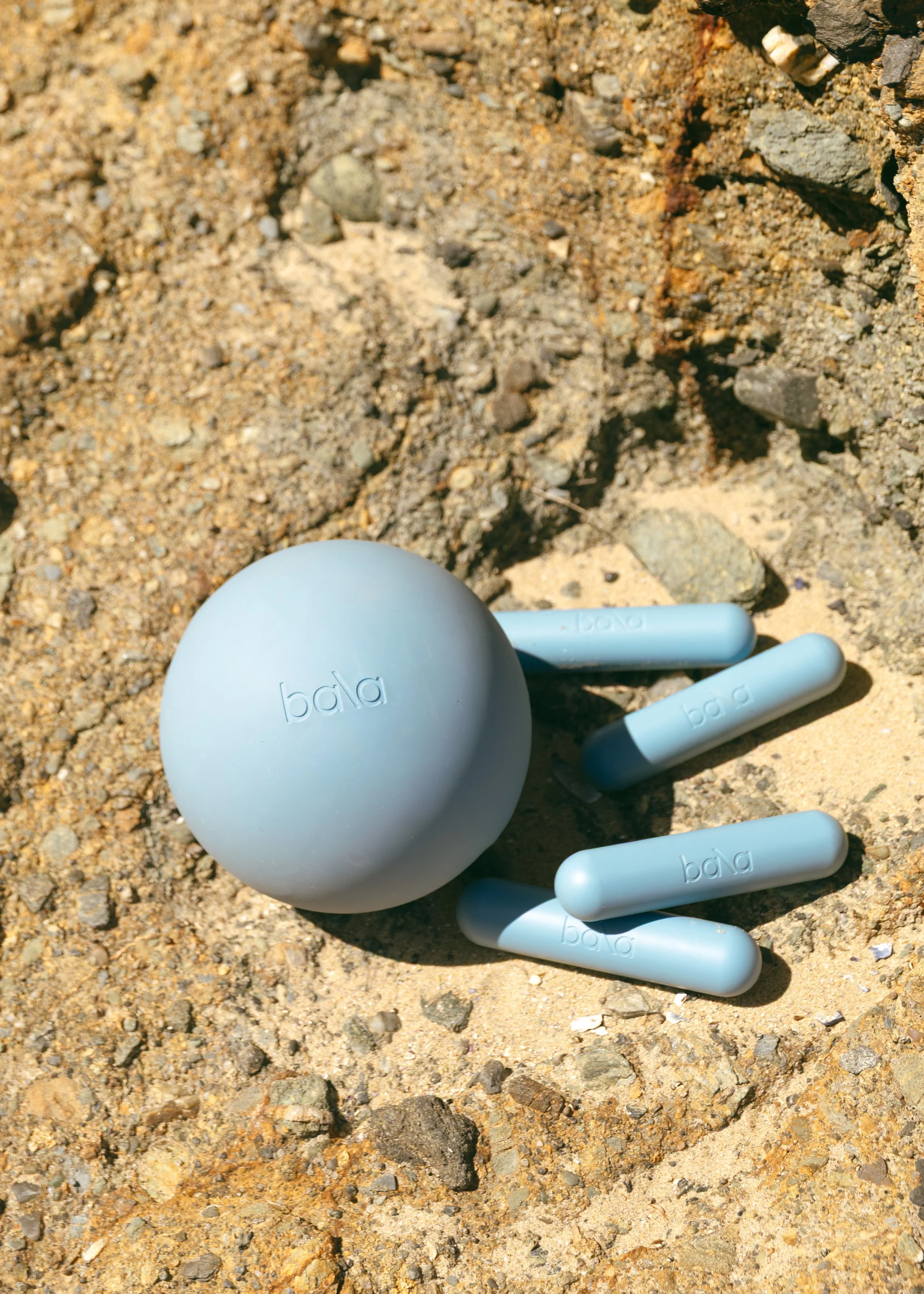 Photo of a Bala ball and Bala weights on top of a rock.