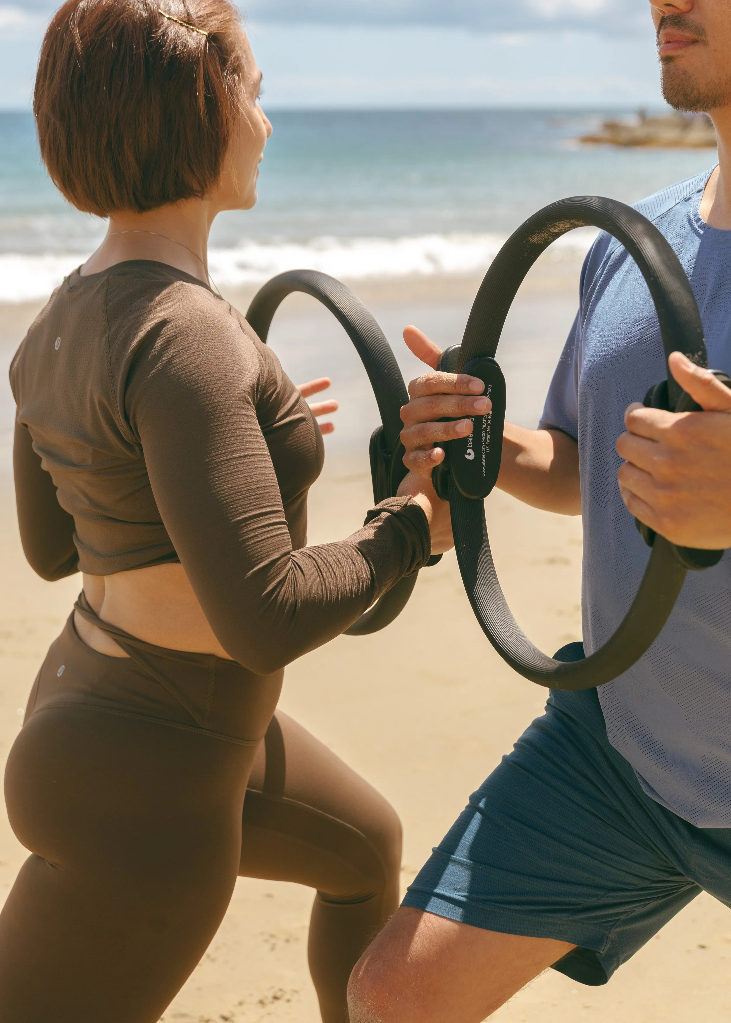 Two people holding Pilates circles.