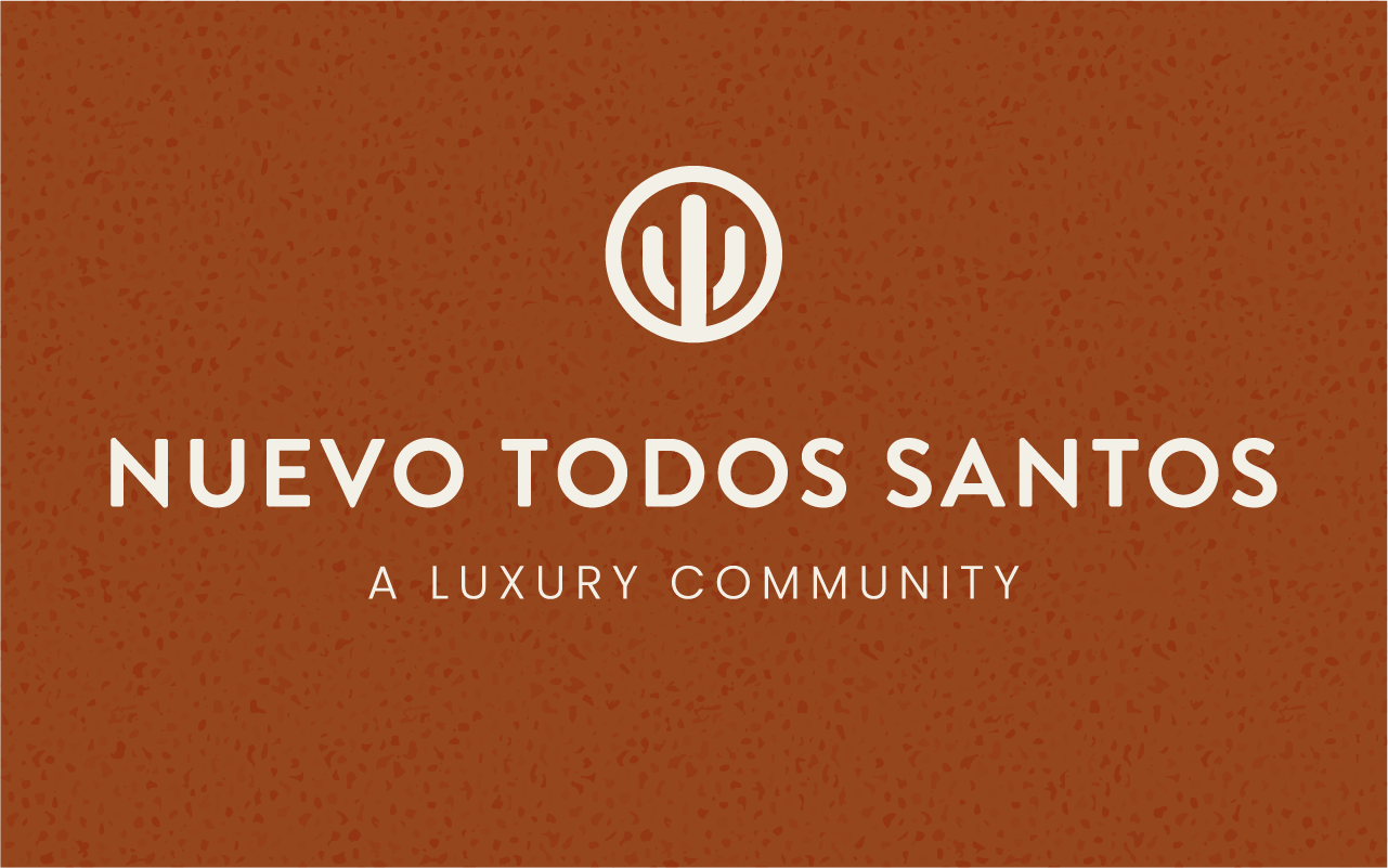Graphic with brown background, white text reading 'Nuevo Todos Santos' and 'A Luxury Community', and a white circular logo with a cactus at the top center.