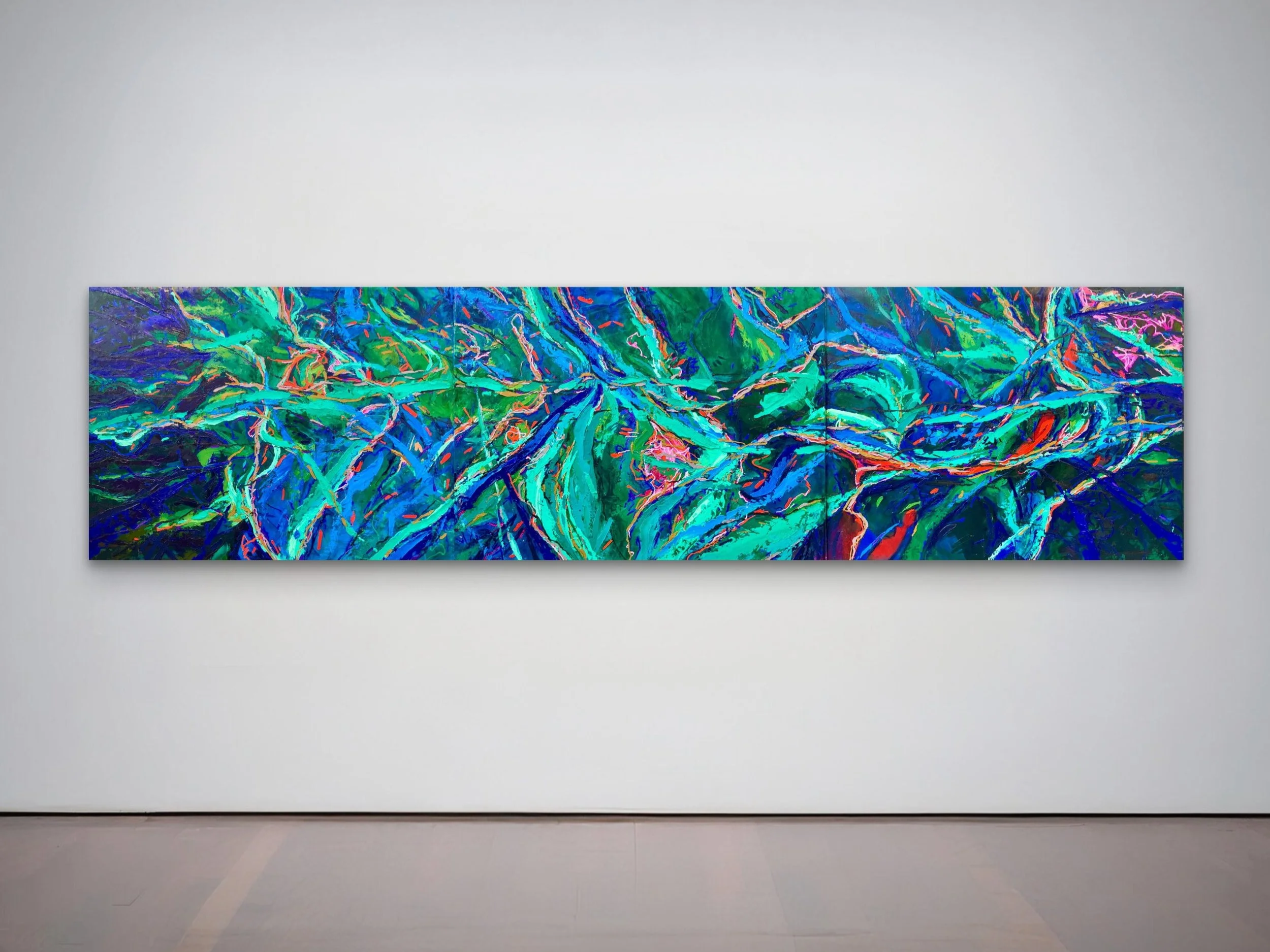 Abstract colorful artwork featuring vibrant blue, green, pink, and orange brushstrokes on a long horizontal canvas in a gallery setting.