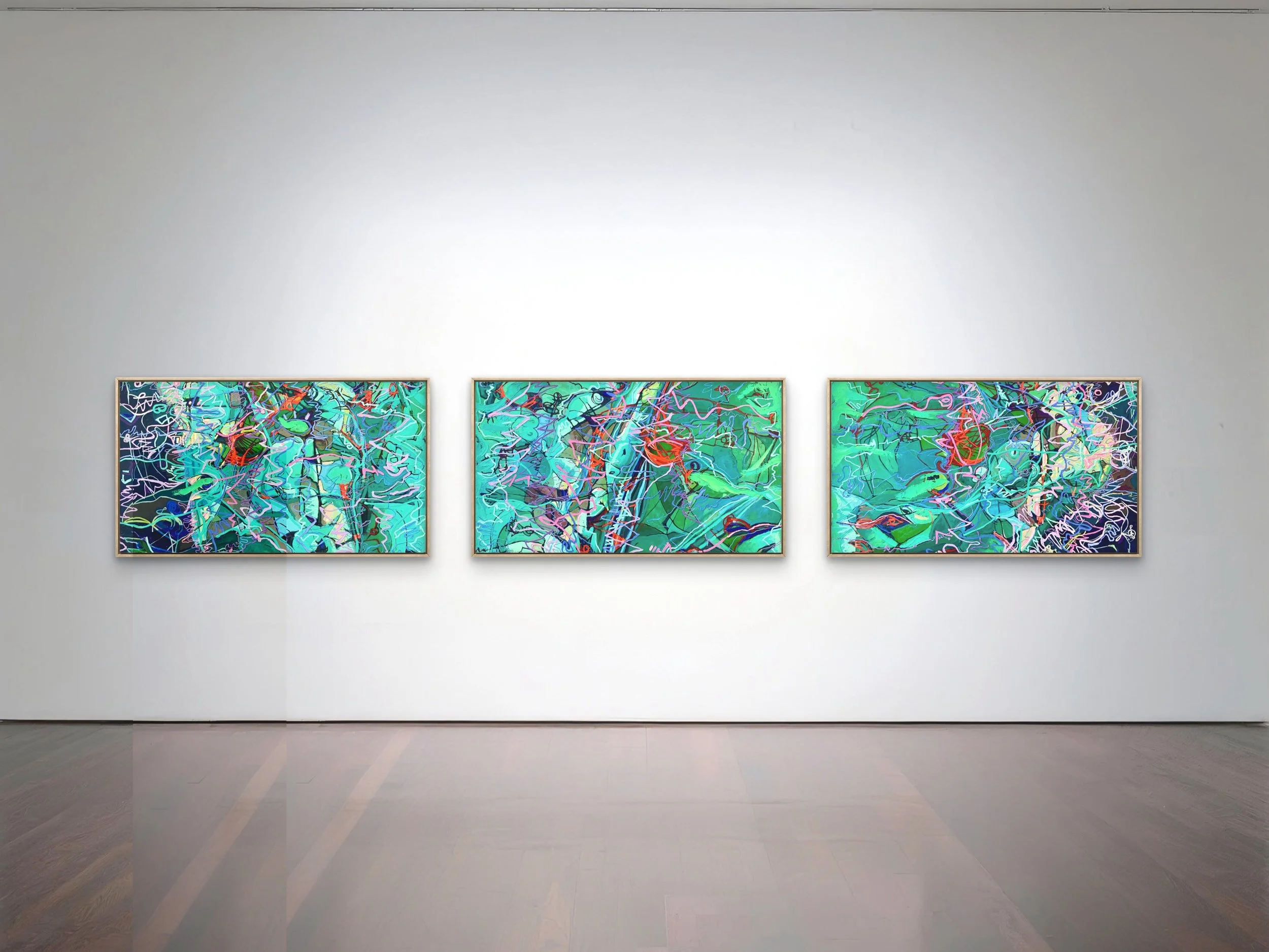 Three abstract colorful paintings displayed side by side in an art gallery with a white wall and wooden floor.