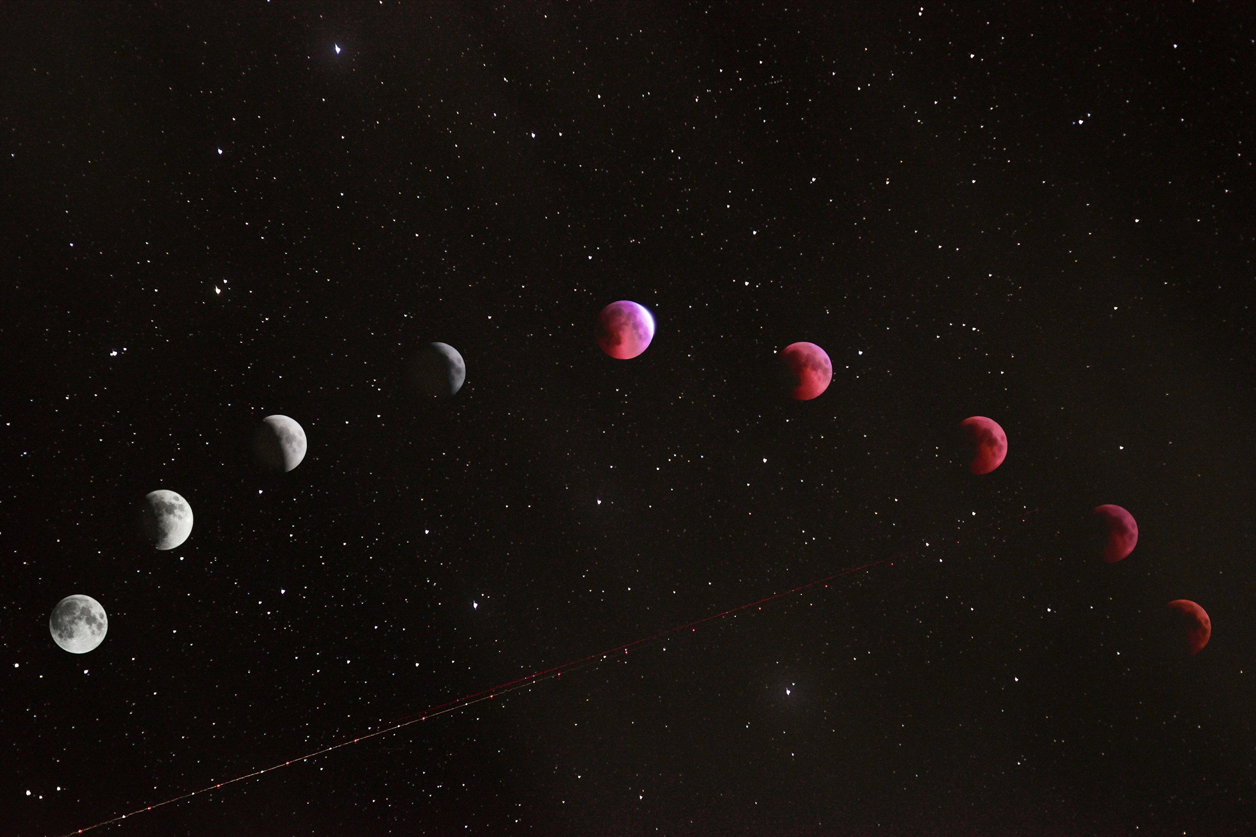 Sequence of images showing the phases of a lunar eclipse against a starry night sky, with a red-tinted moon during totality.