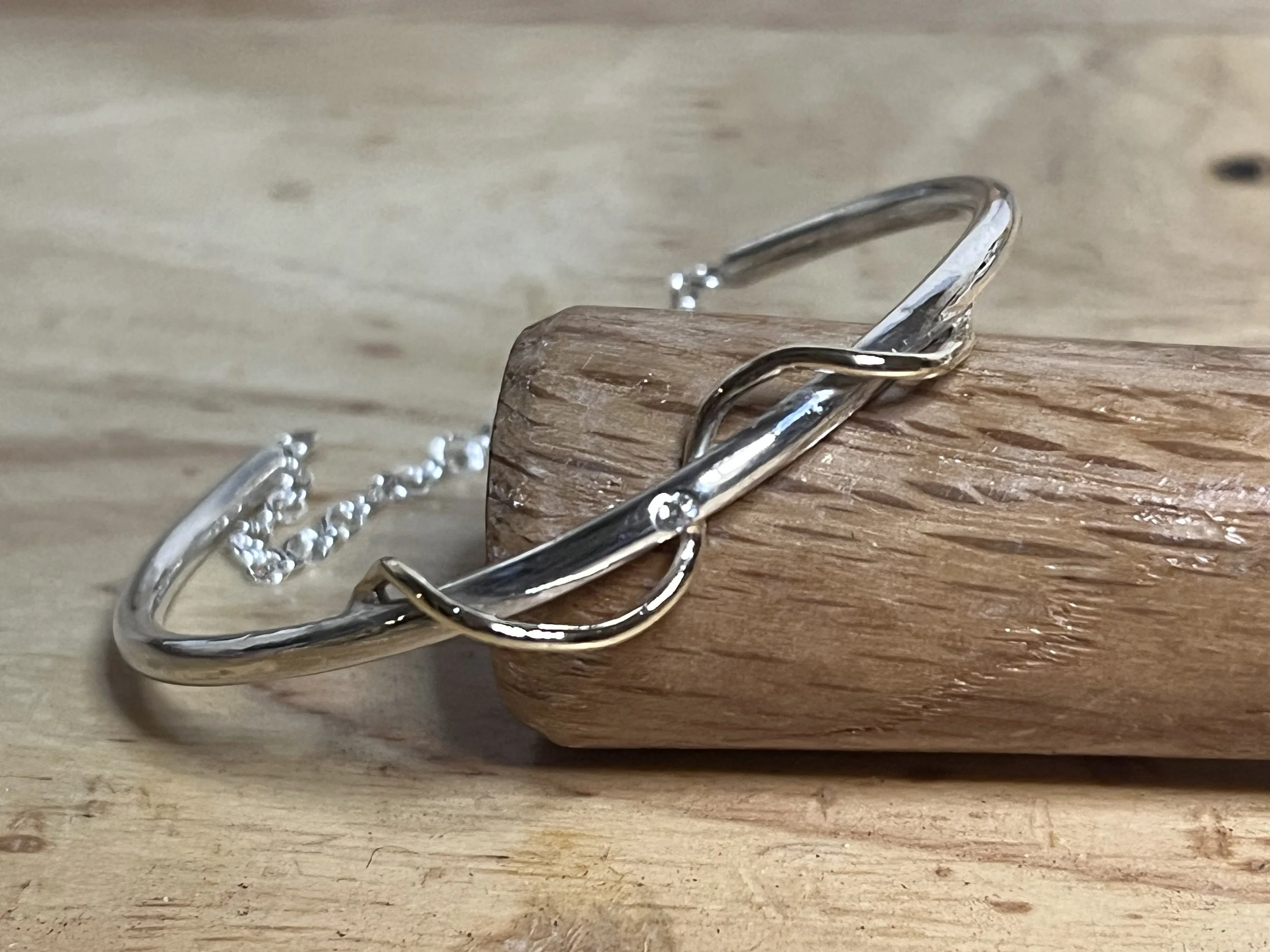 Silver bangle with a catch chain and 9ct gold detail 