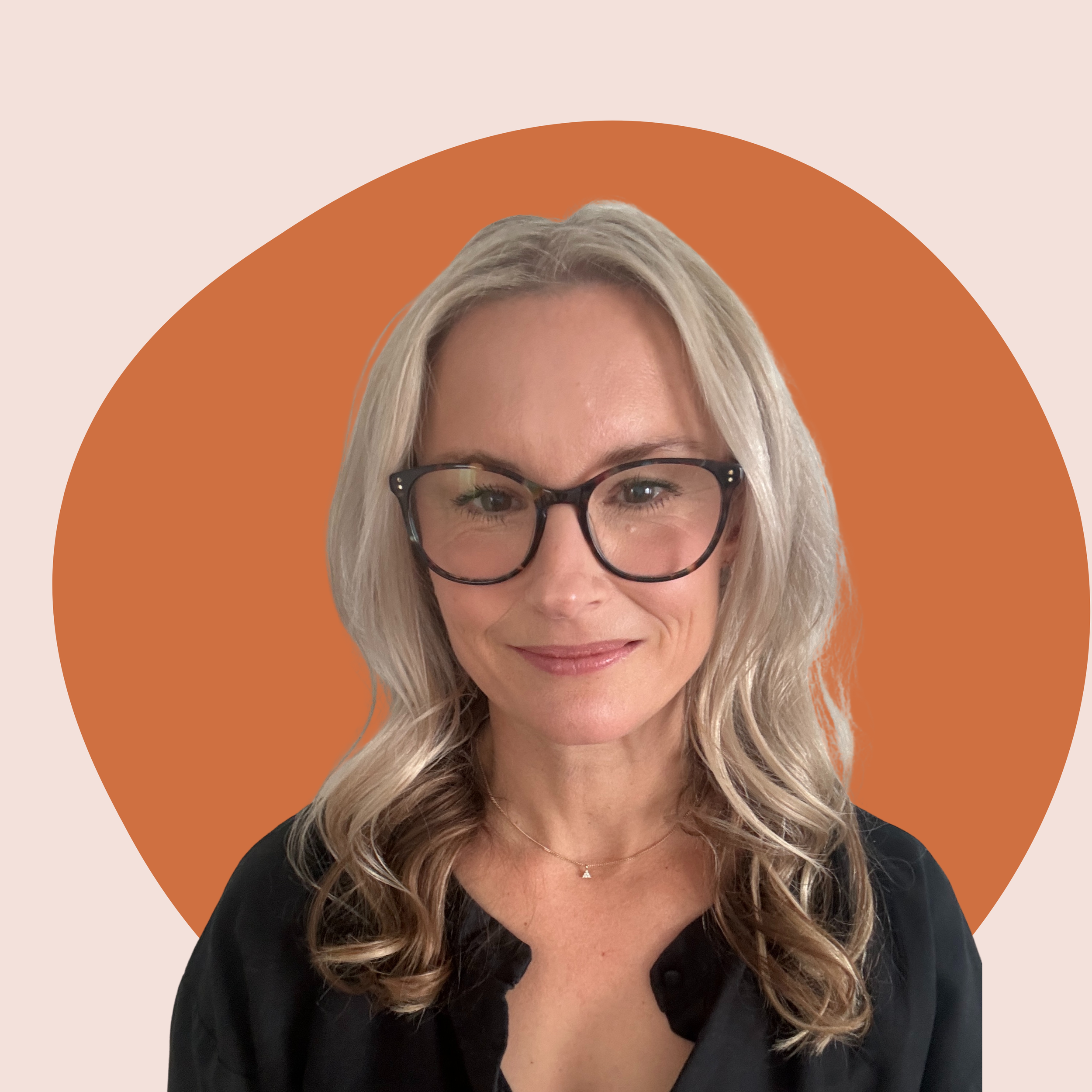 A woman with blonde hair, glasses, and a black top smiling against an abstract background with a large orange circle.