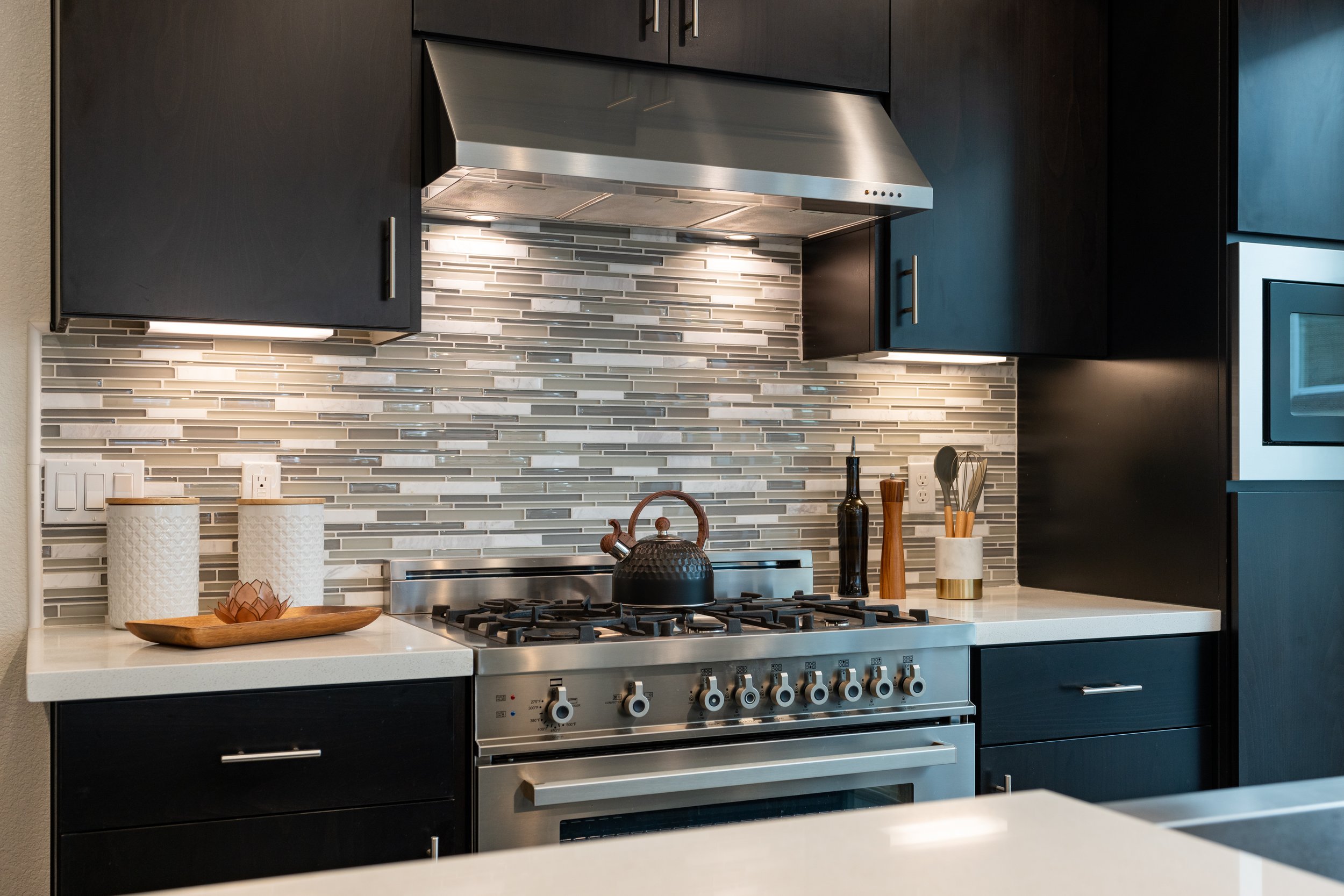 Renovated kitchen with a new stainless steel gas stove and oven.