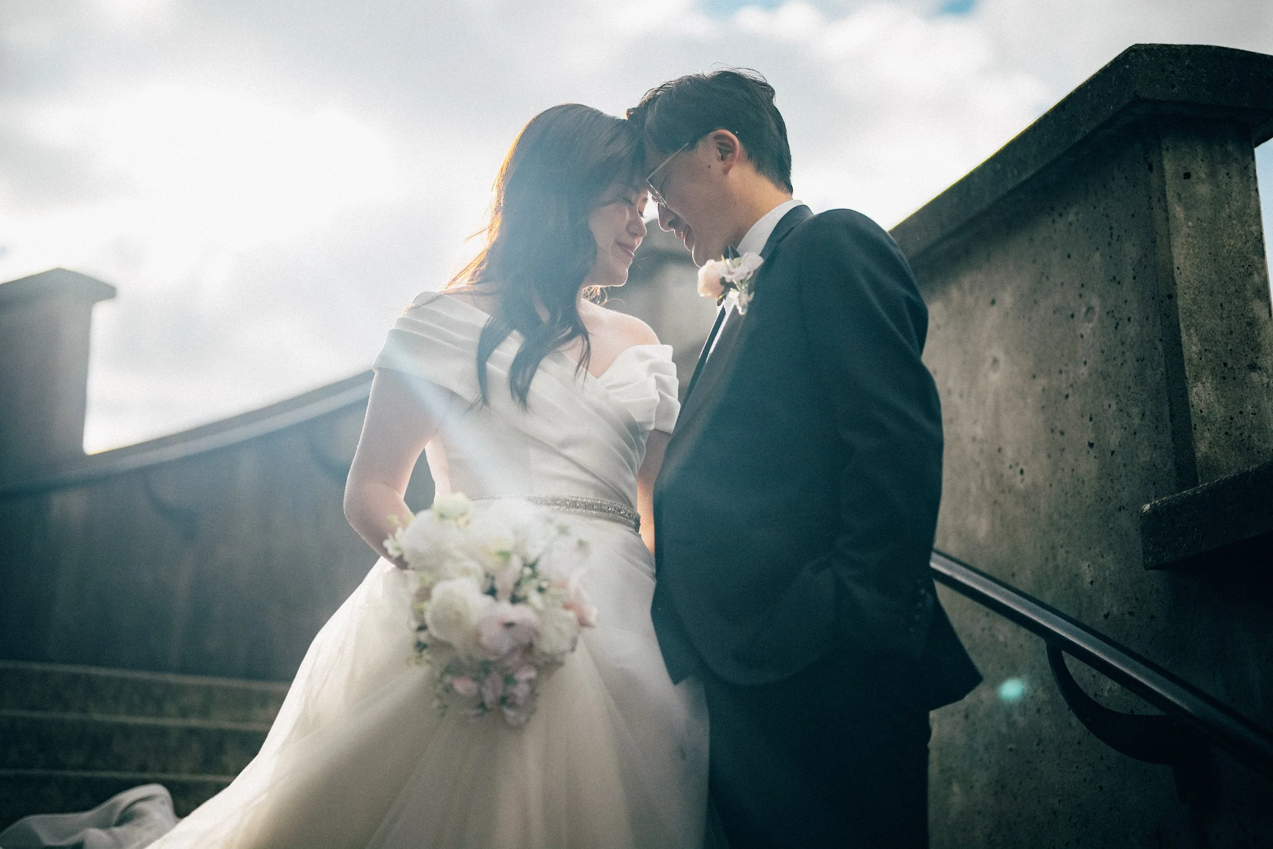  A tender, backlit portrait of the couple standing closely on the steps. 