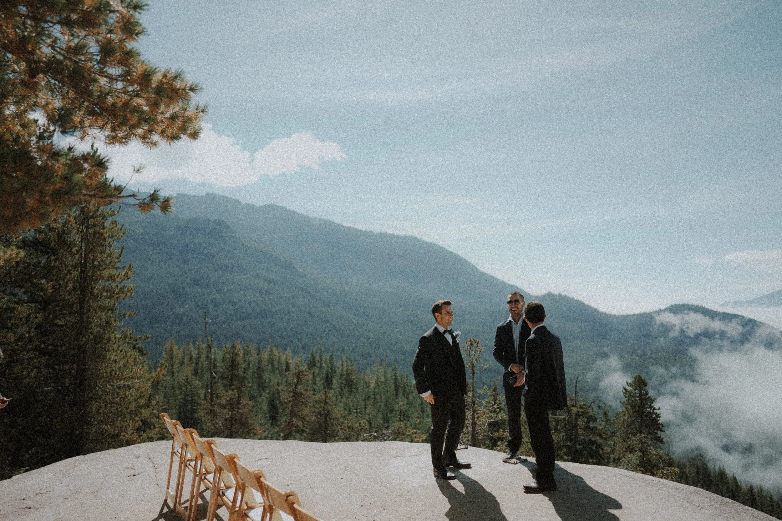 Two suited wedding guests standing at the mountain ceremony viewpoint.
