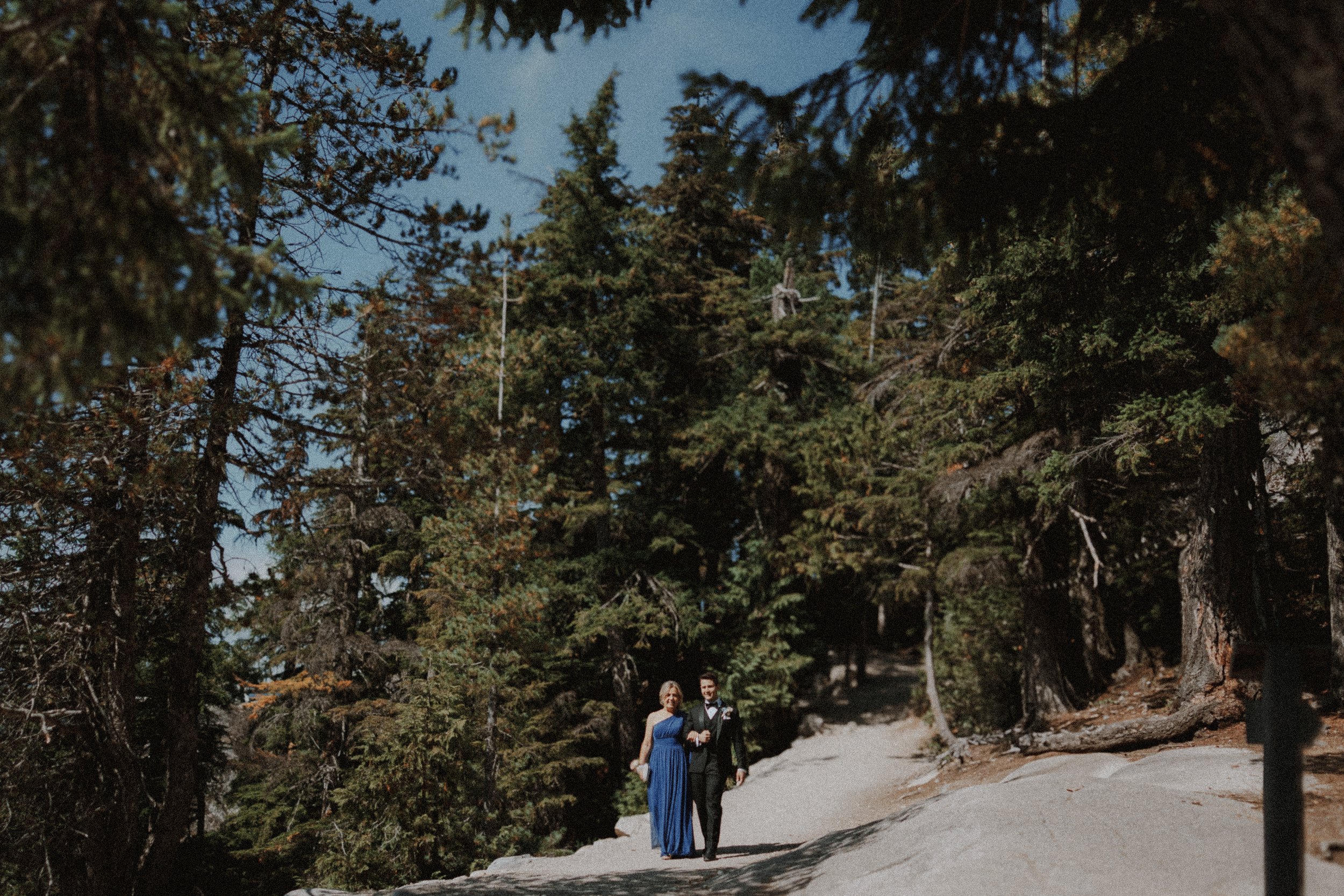 Guests approaching the ceremony along a wide mountain trail.