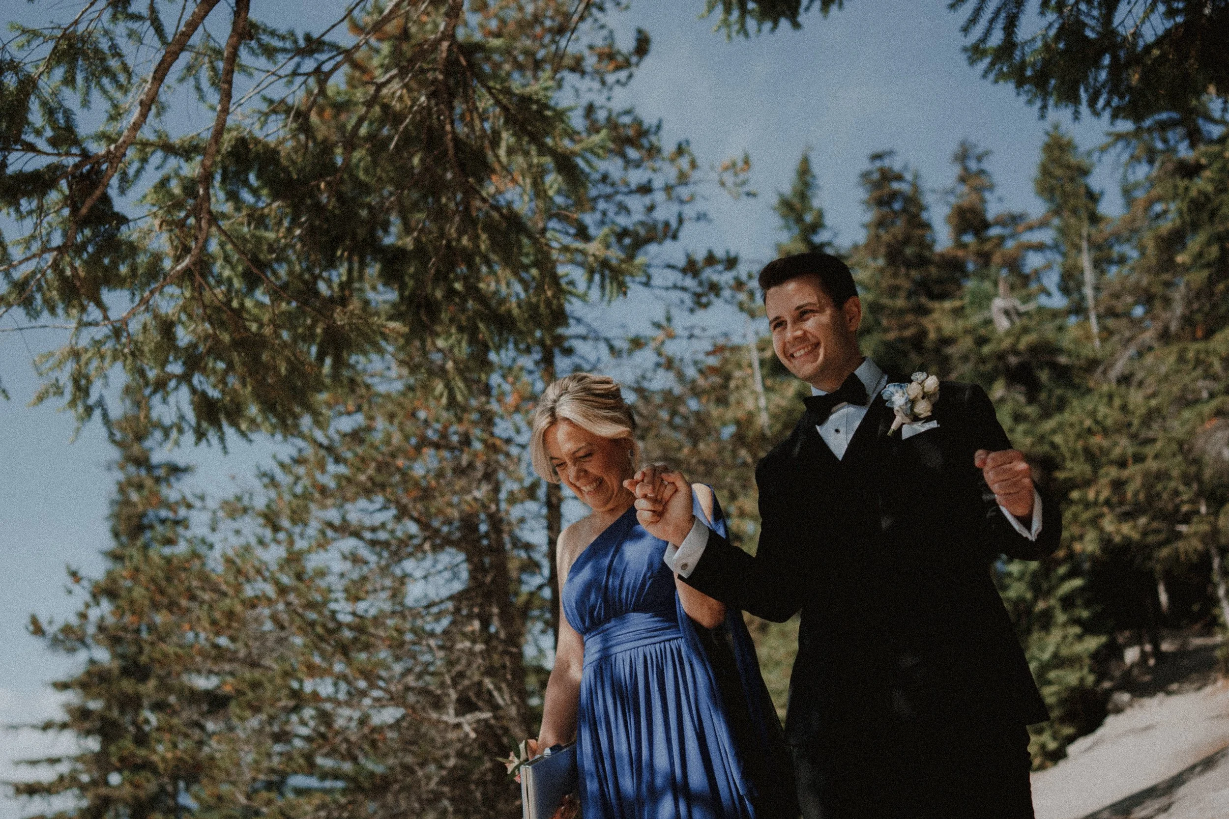 Groom walking arm in arm with a guest toward the outdoor ceremony.