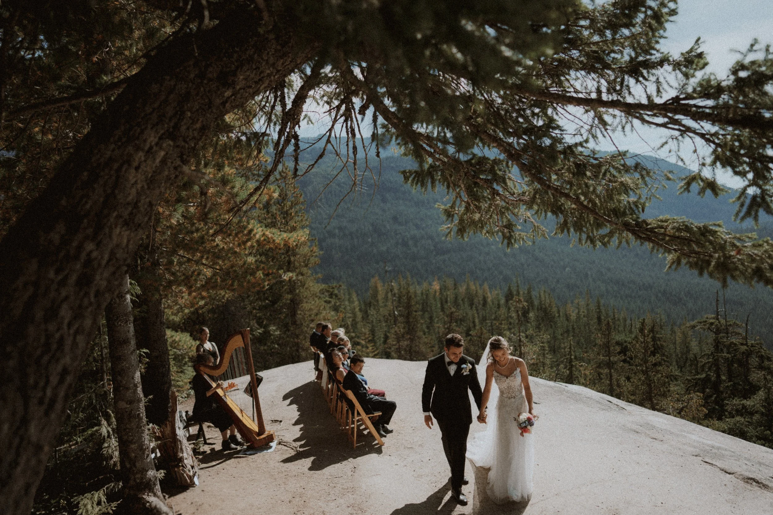 Bride and groom leaving the mountain ceremony hand in hand.
