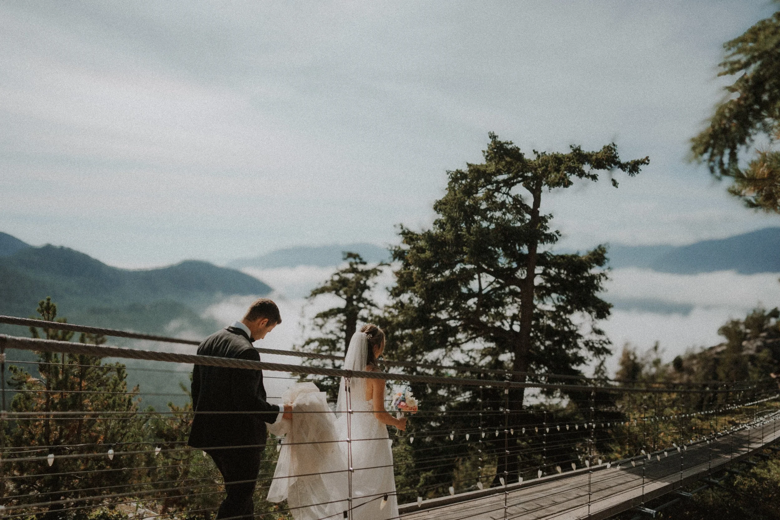 Bride and groom holding hands on the Sea to Sky Gondola suspension bridge.